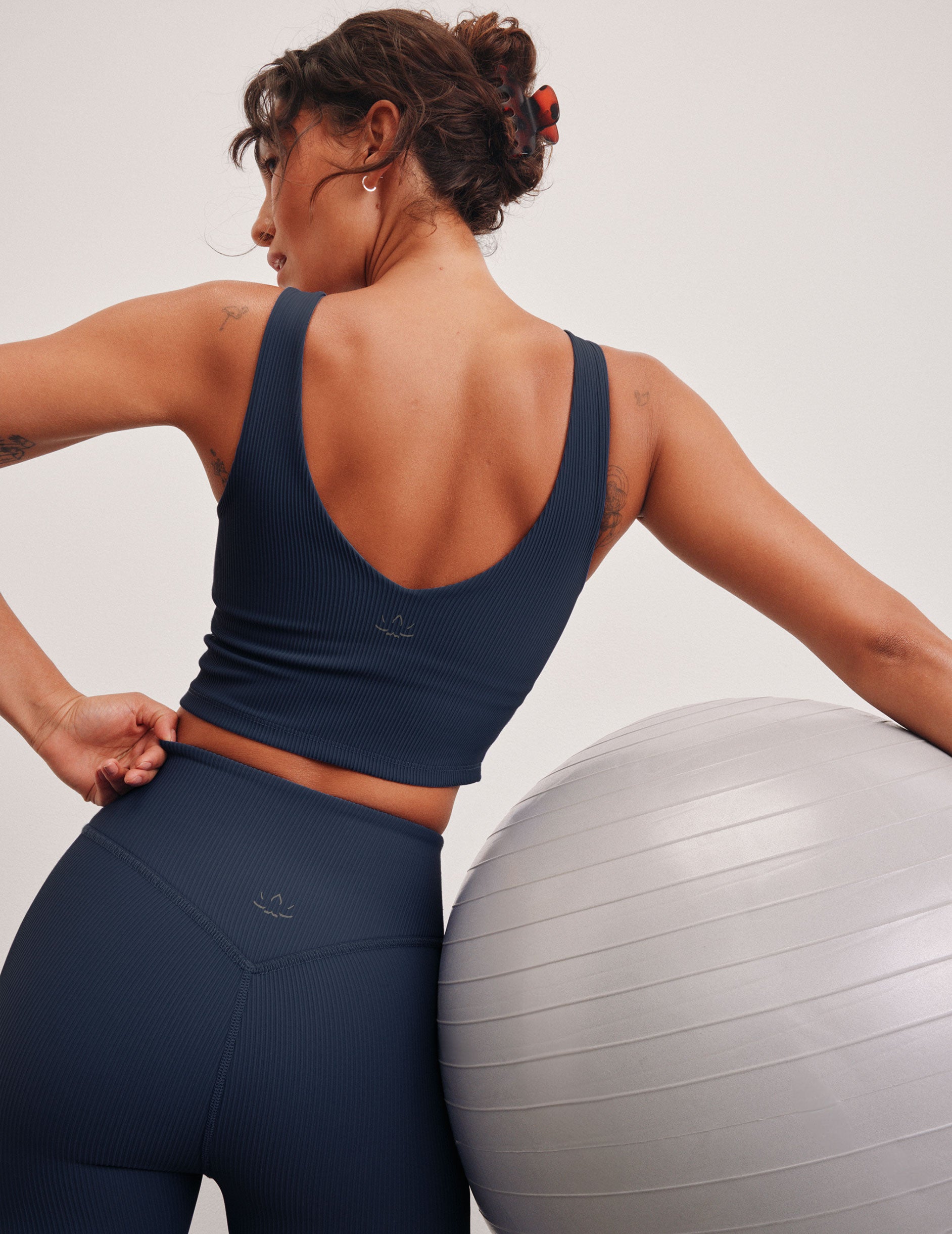 blue ribbed cropped tank top with a soft V neckline front and back, an overlapping front neckline detail, and a lining shelf bra.