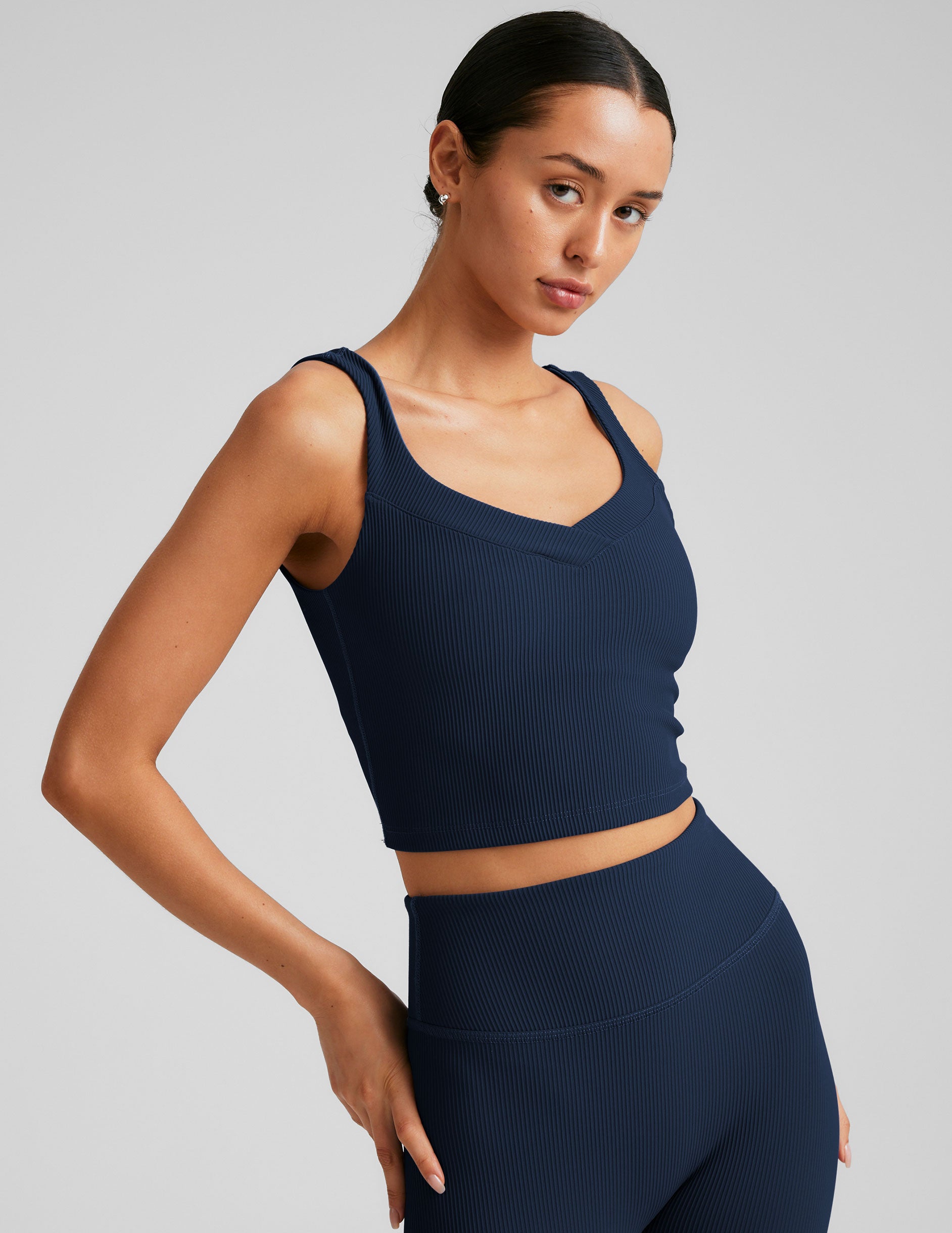 blue ribbed cropped tank top with a soft V neckline front and back, an overlapping front neckline detail, and a lining shelf bra.