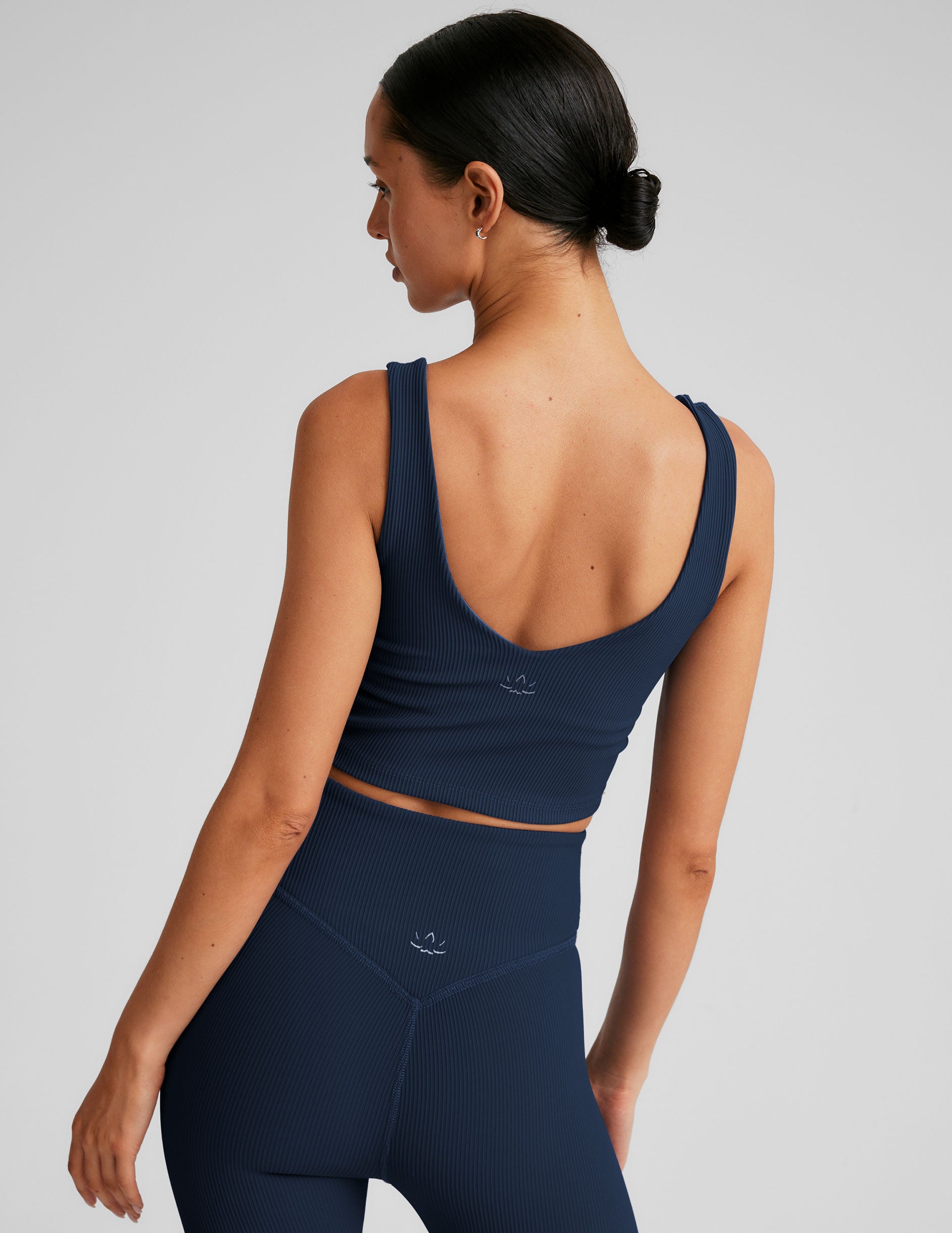 blue ribbed cropped tank top with a soft V neckline front and back, an overlapping front neckline detail, and a lining shelf bra.