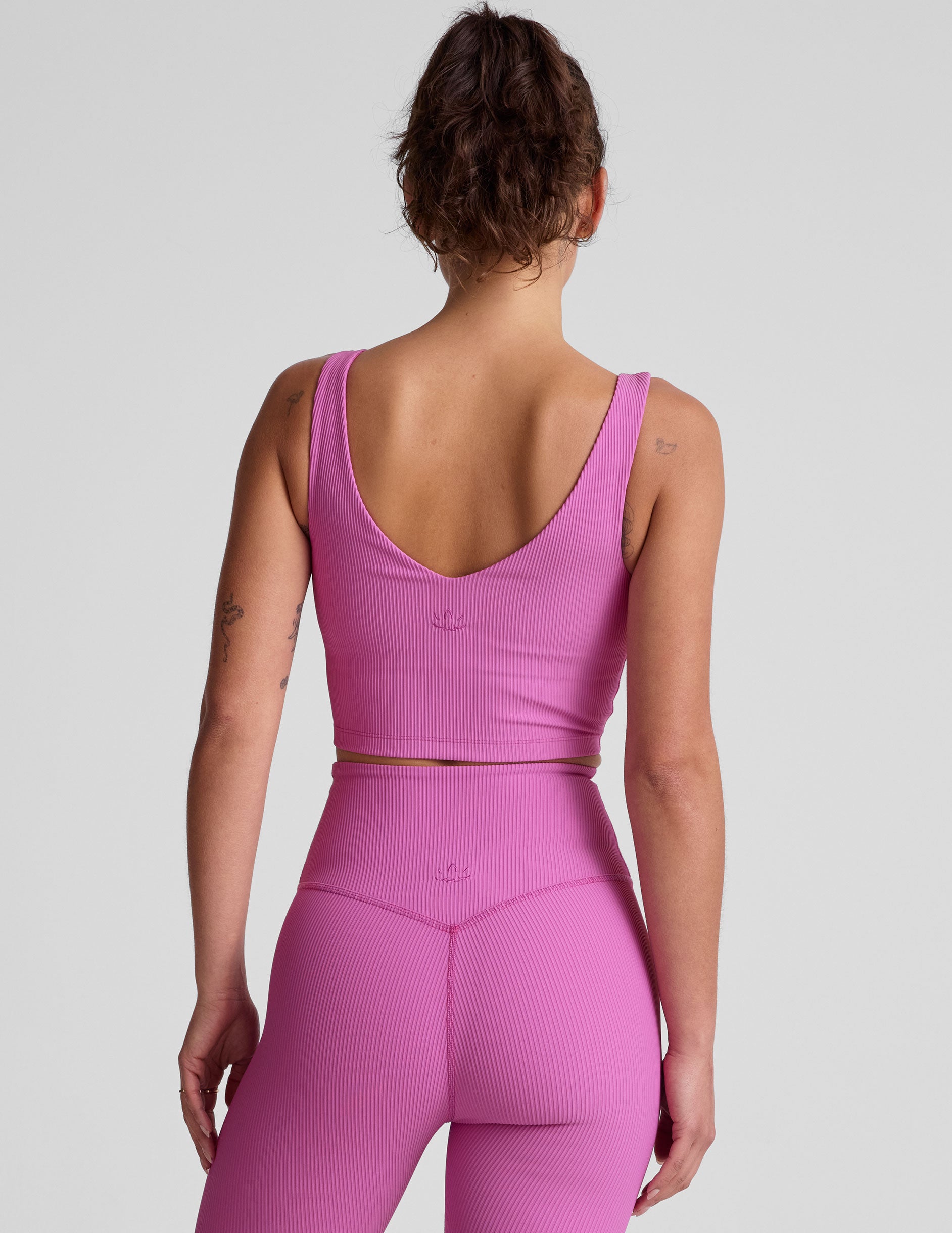 pink ribbed cropped tank top with a soft V neckline front and back, an overlapping front neckline detail, and a lining shelf bra.