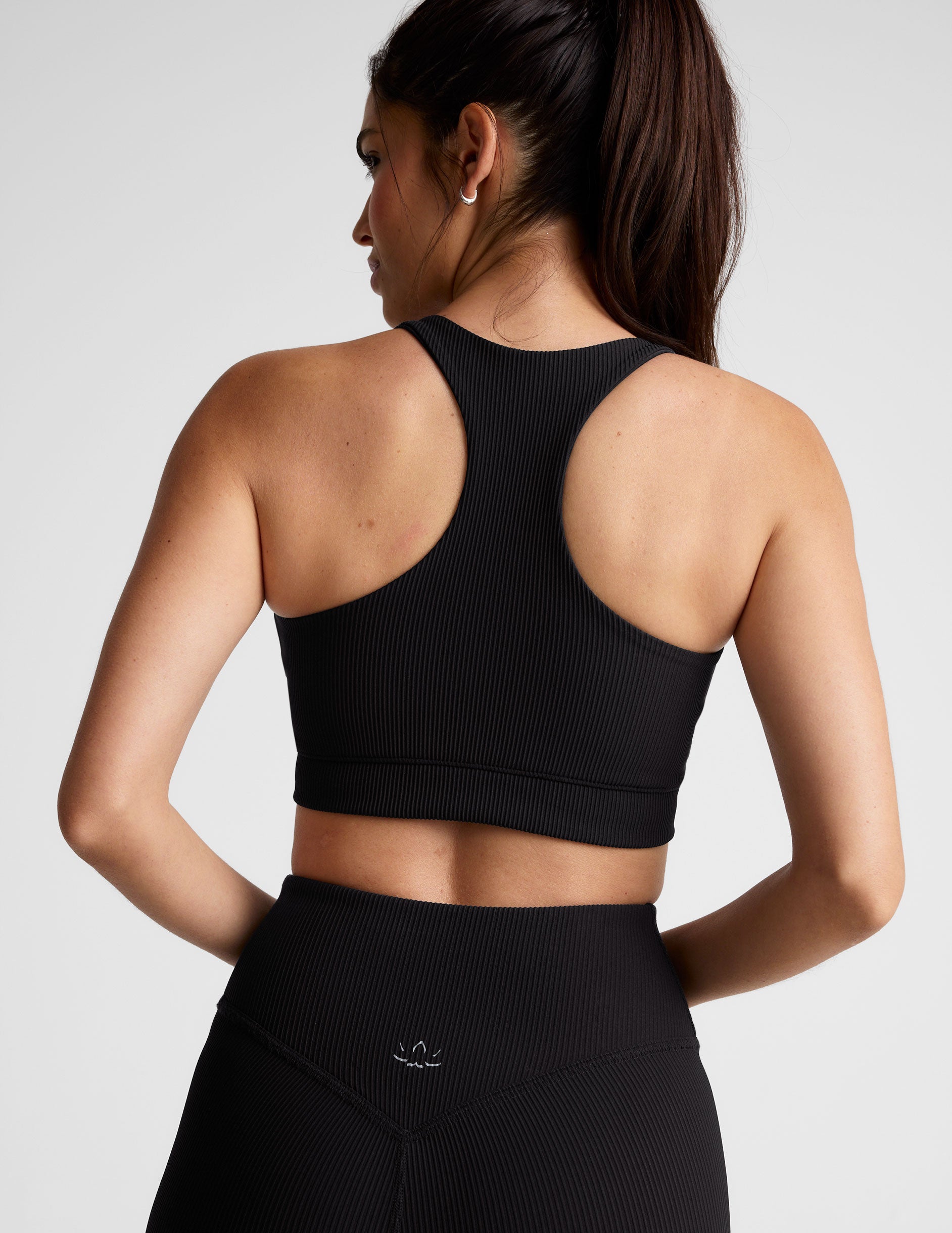black ribbed racerback bra with overlapping hemband detail and a scoop neckline.