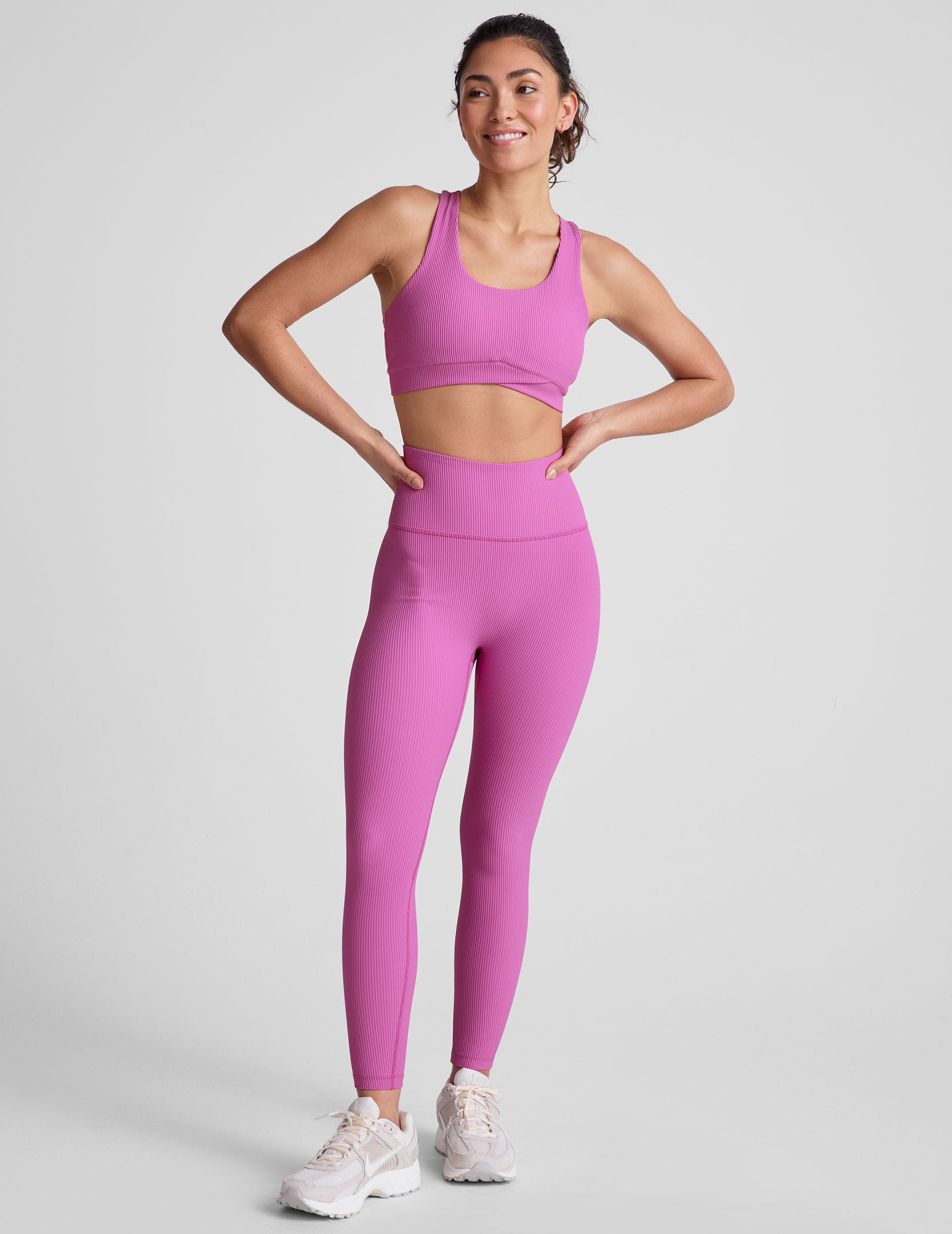 pink medium support racerback bra with a scoop neckline, overlapping hemband detail, is lined with performance lining and powermesh in between, and has removable bra pads.