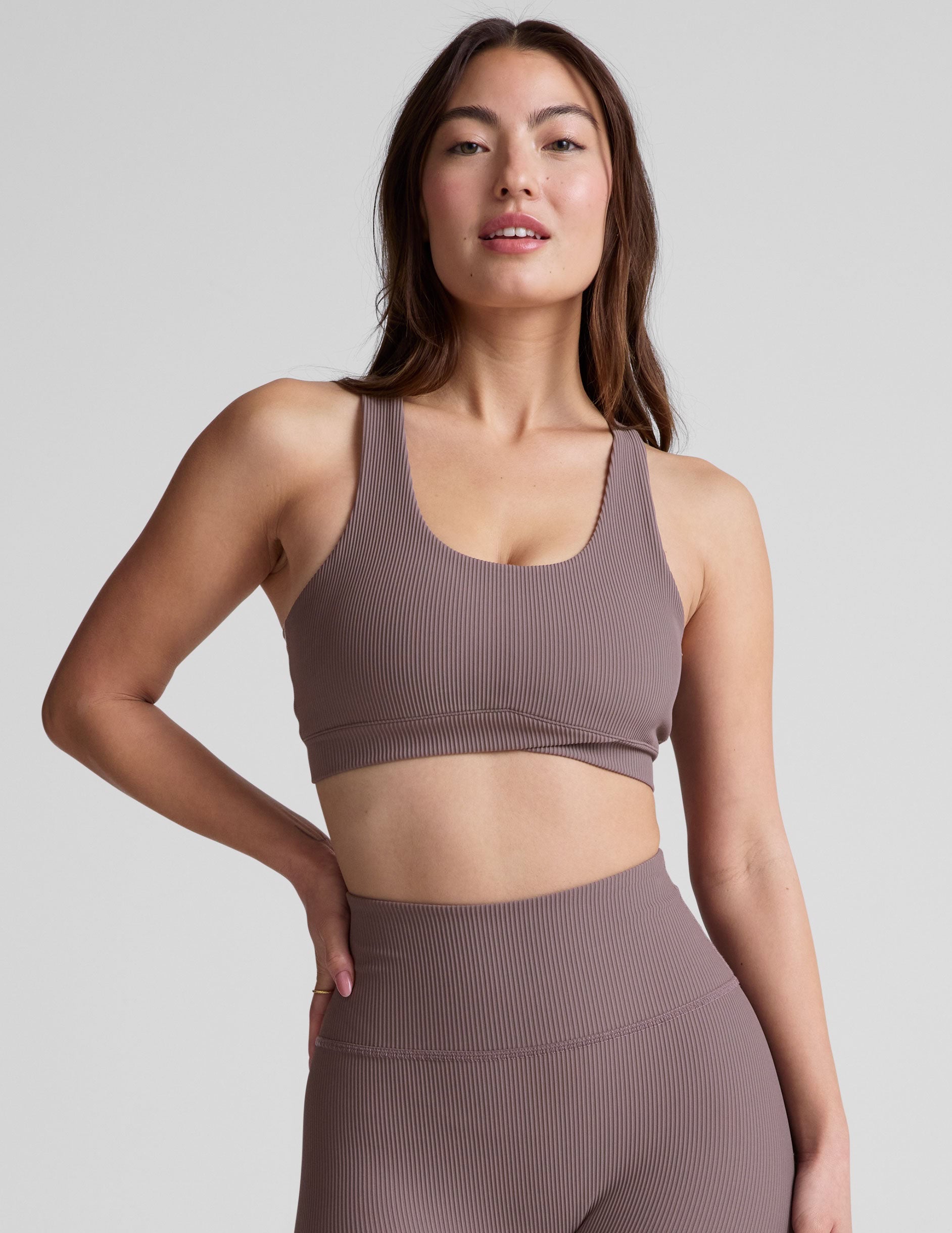 brown medium support racerback bra with a scoop neckline, overlapping hemband detail, is lined with performance lining and powermesh in between, and has removable bra pads.