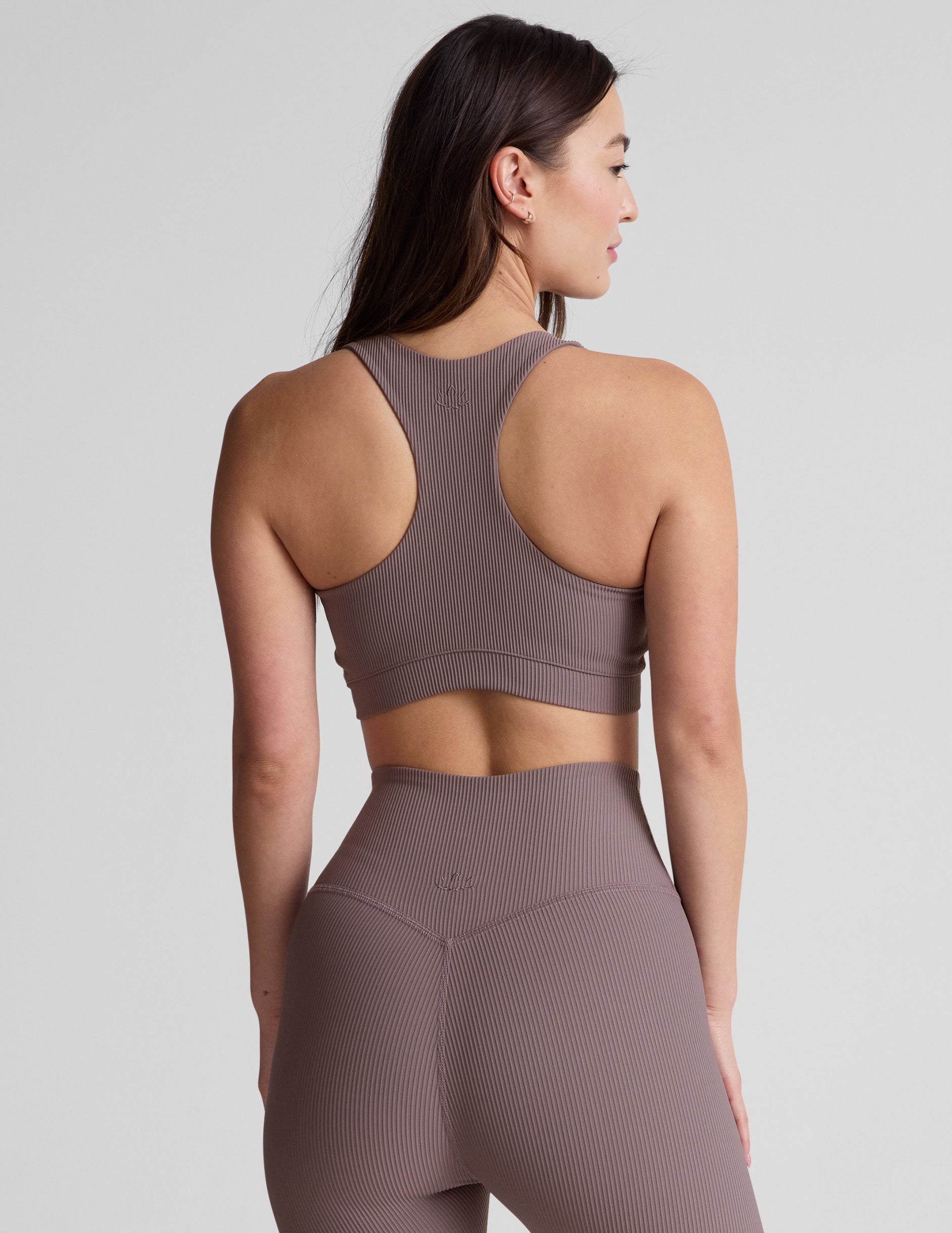 brown medium support racerback bra with a scoop neckline, overlapping hemband detail, is lined with performance lining and powermesh in between, and has removable bra pads.