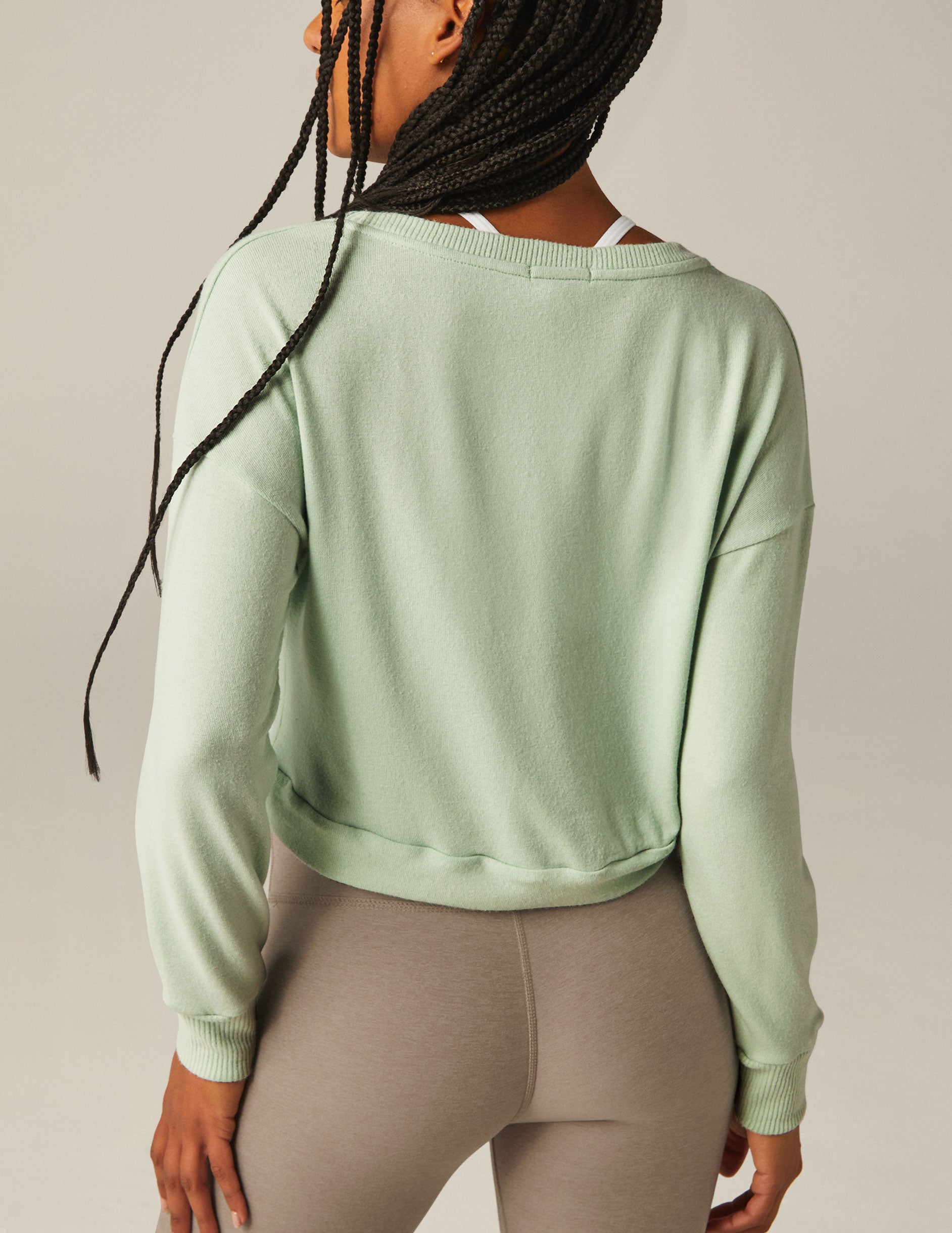 green scoop neck cropped pullover with a front tie detail.