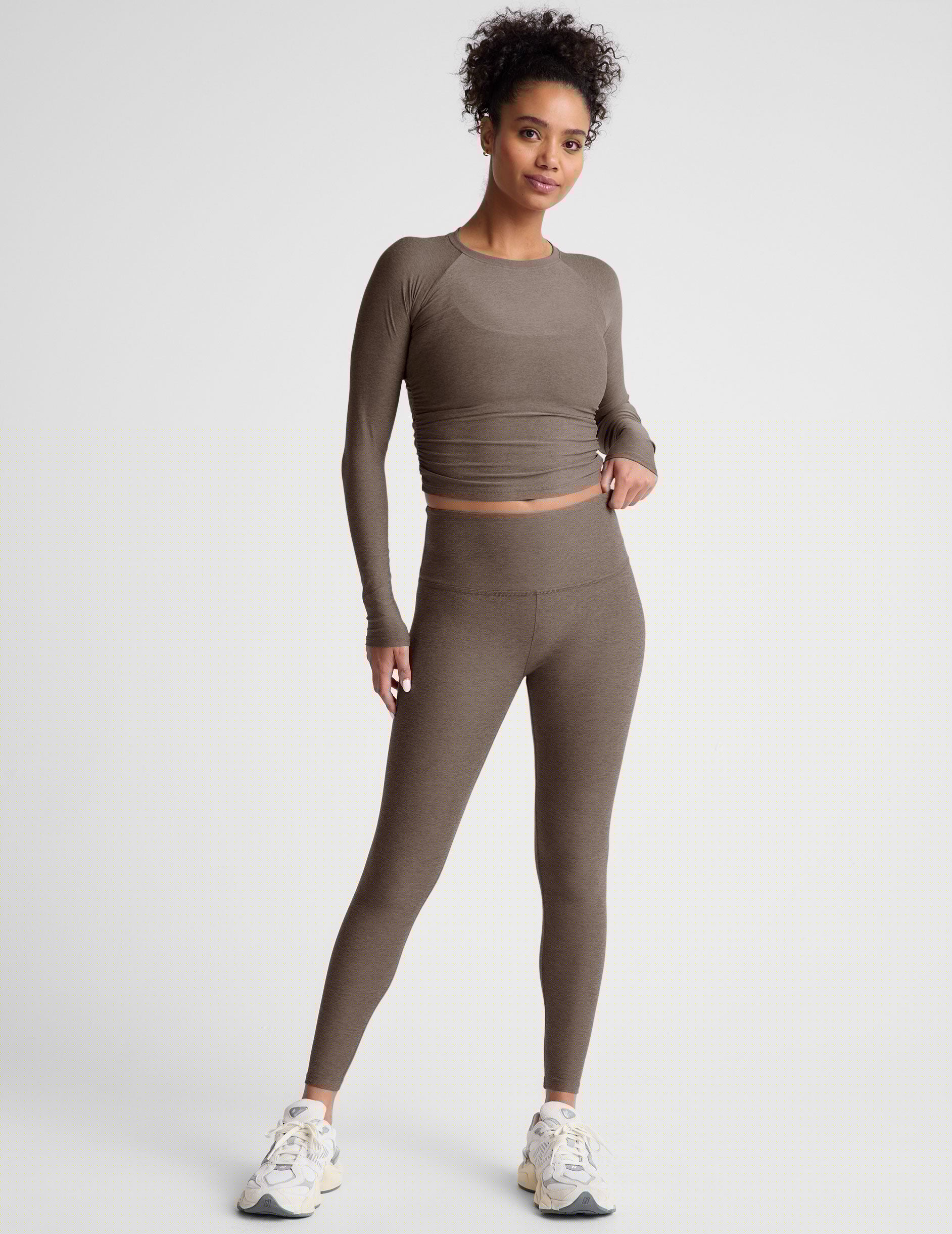 brown long sleeve cropped top with shirred detailing on the sides.