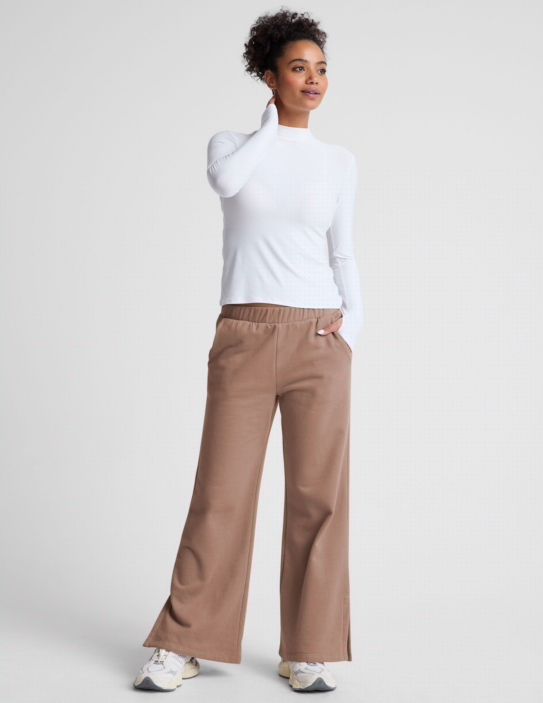 brown wide leg sweatpants with pockets and side slits by ankle.