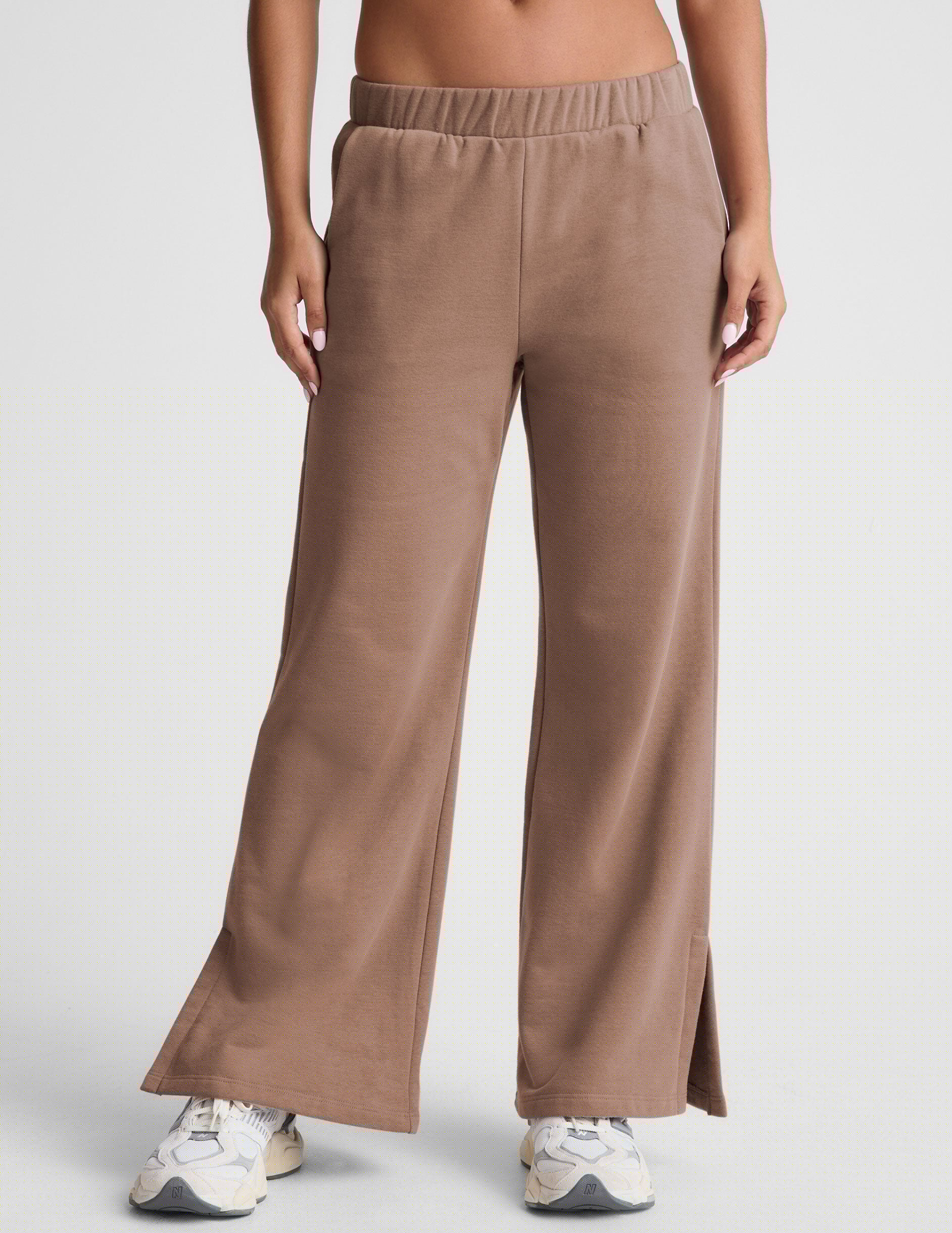 brown wide leg sweatpants with pockets and side slits by ankle.