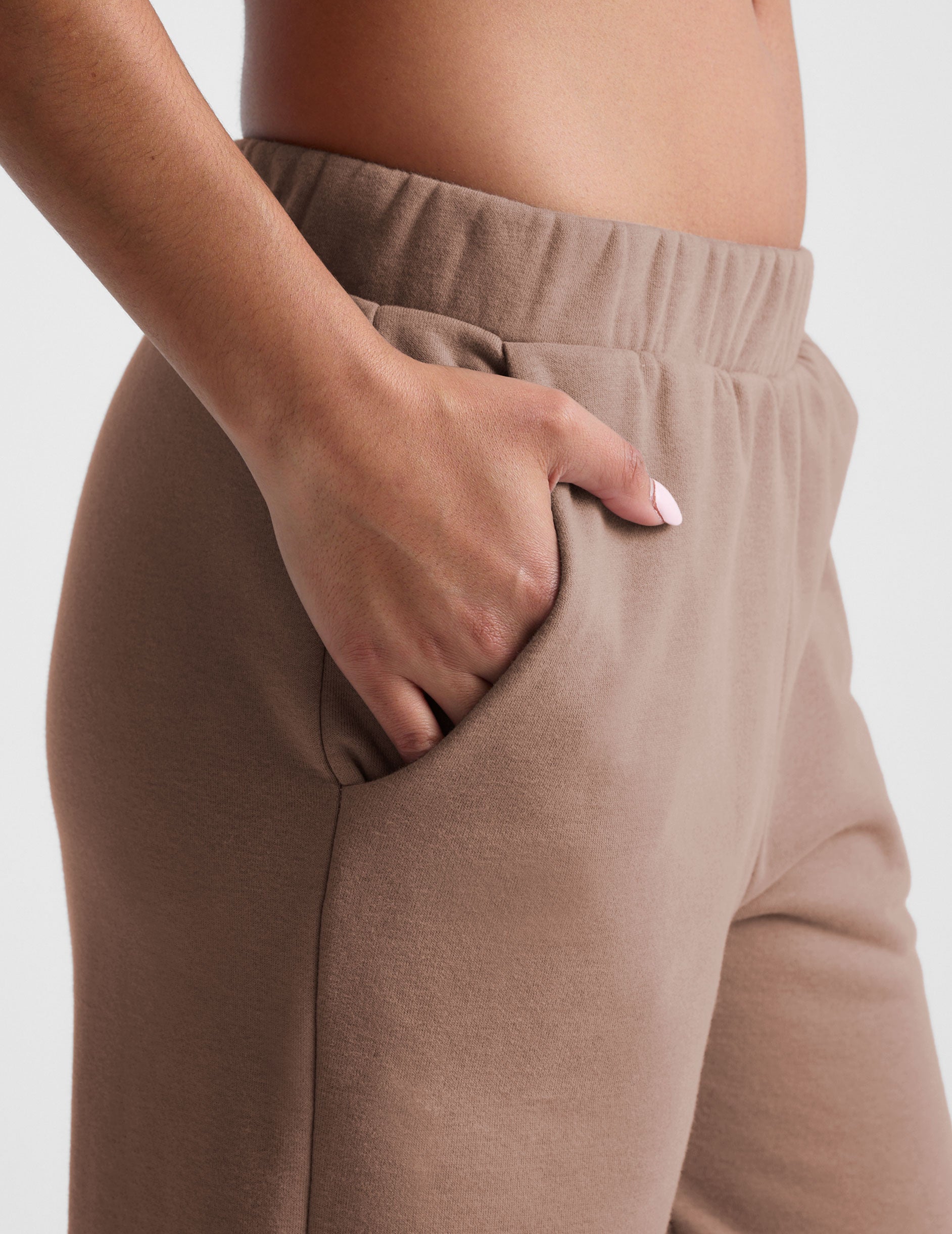 brown wide leg sweatpants with pockets and side slits by ankle.