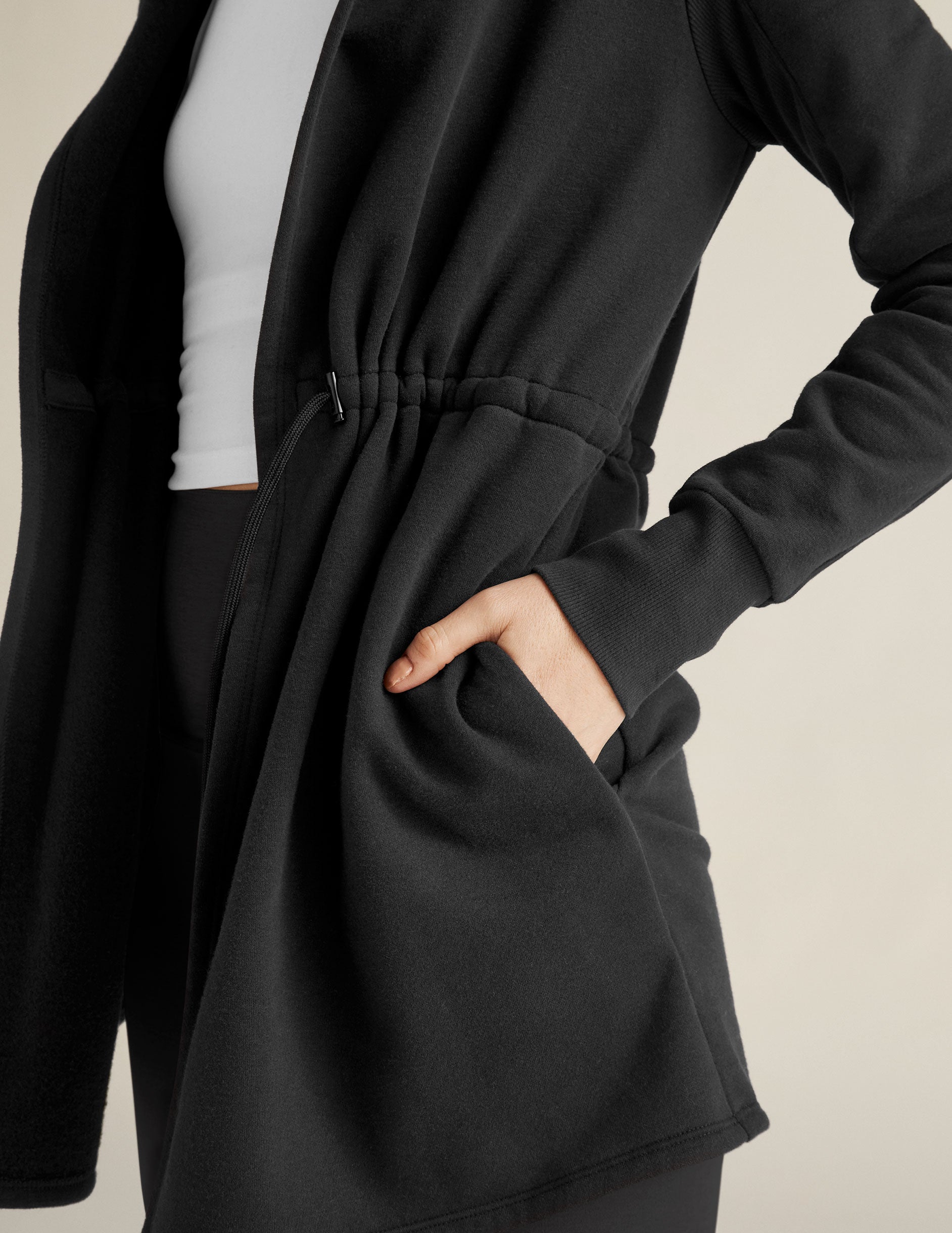 black jacket with a drawstring at the waist.