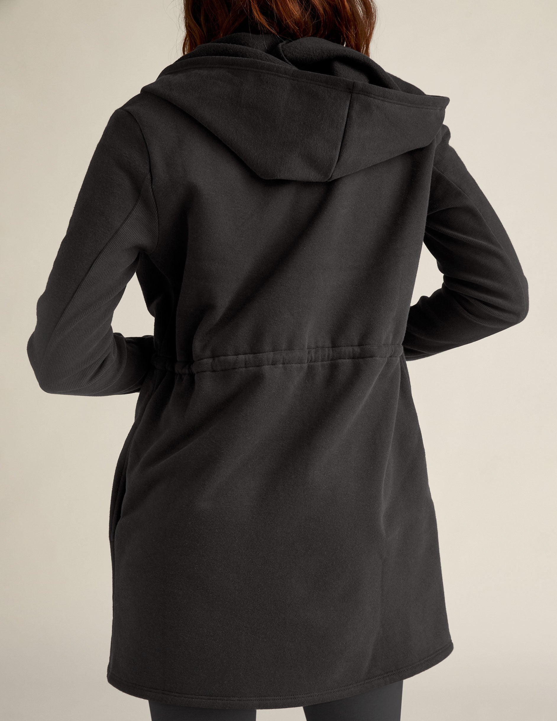 black jacket with a drawstring at the waist.