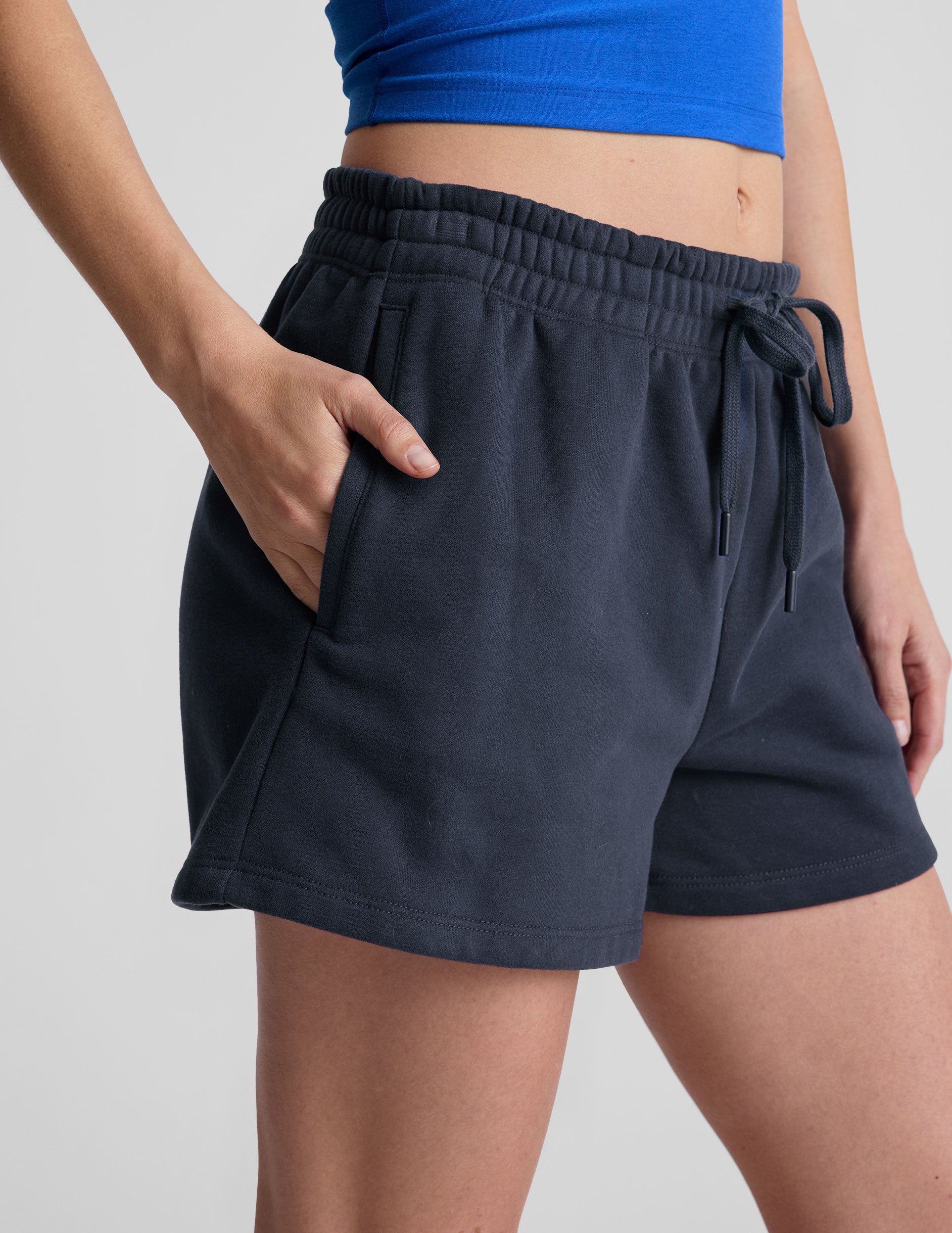 blue sweat shorts with pockets and a drawstring at waistband.
