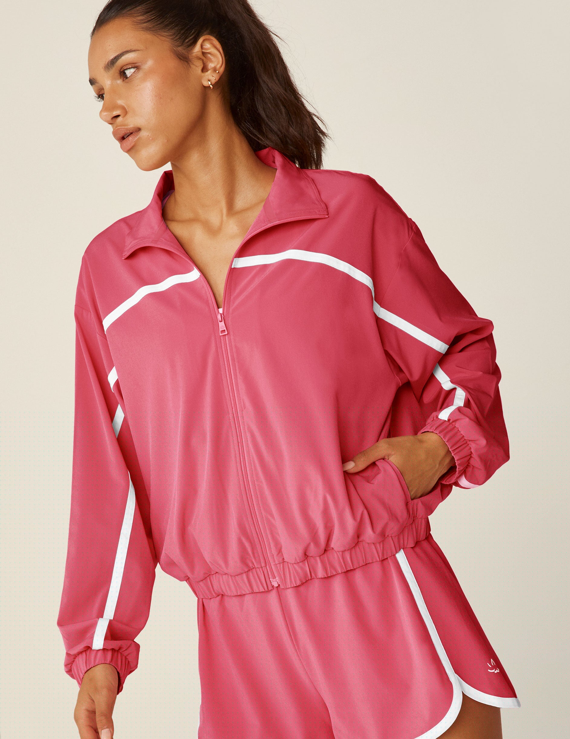 pink zip-up jacket with white trim and pockets.