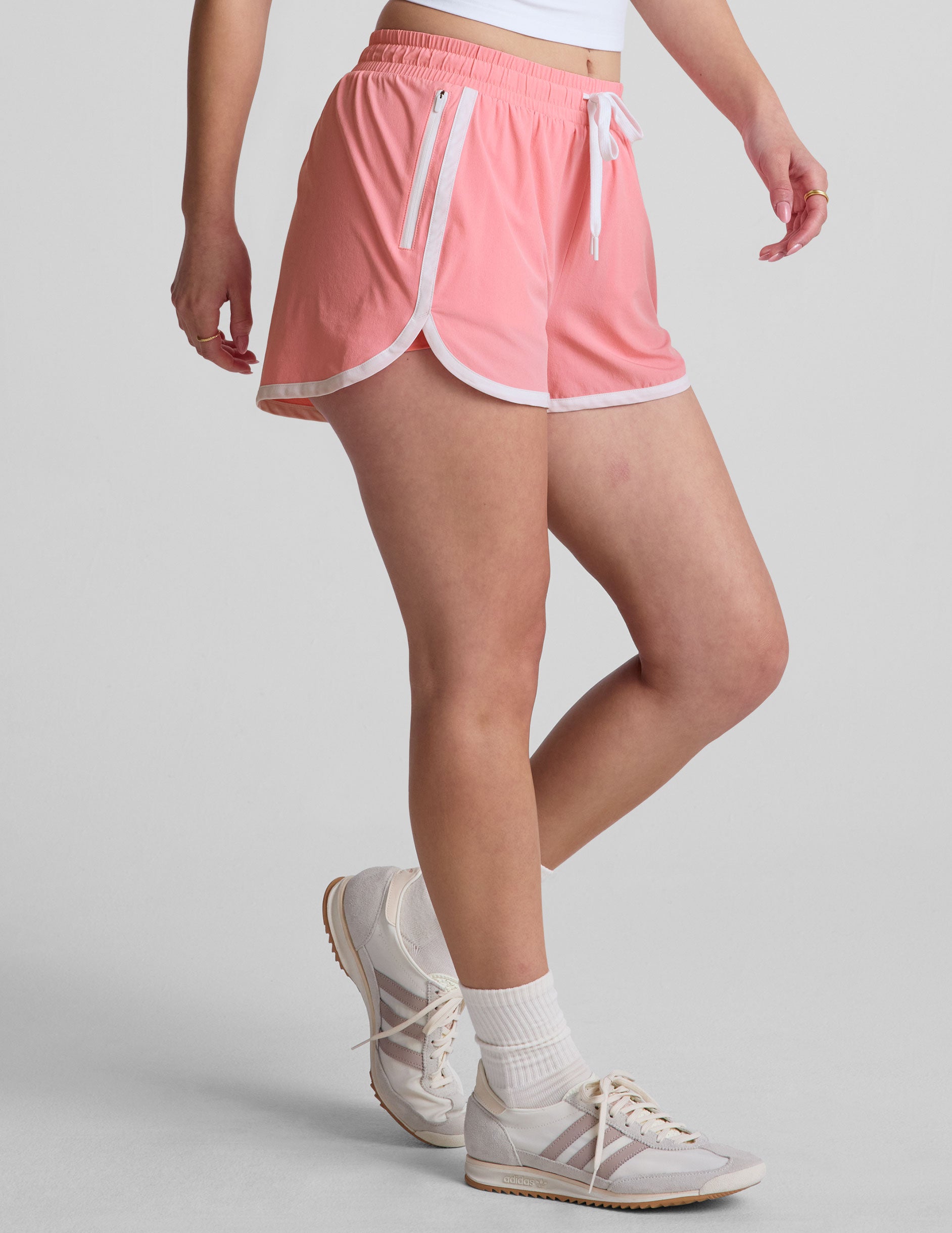 pink 2.5" inseam short with an encased elastic at waistband with drawcord, self binding at hem edges, side zipper pockets, and interior performance lining shorts.