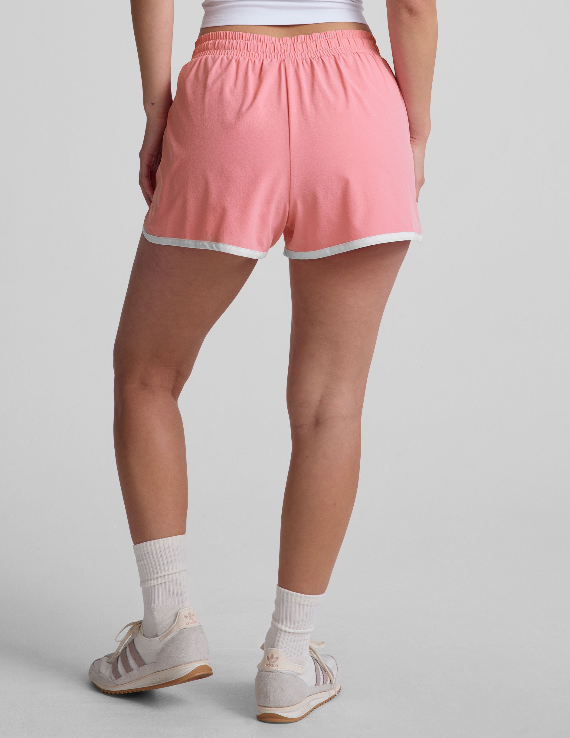 pink 2.5" inseam short with an encased elastic at waistband with drawcord, self binding at hem edges, side zipper pockets, and interior performance lining shorts.
