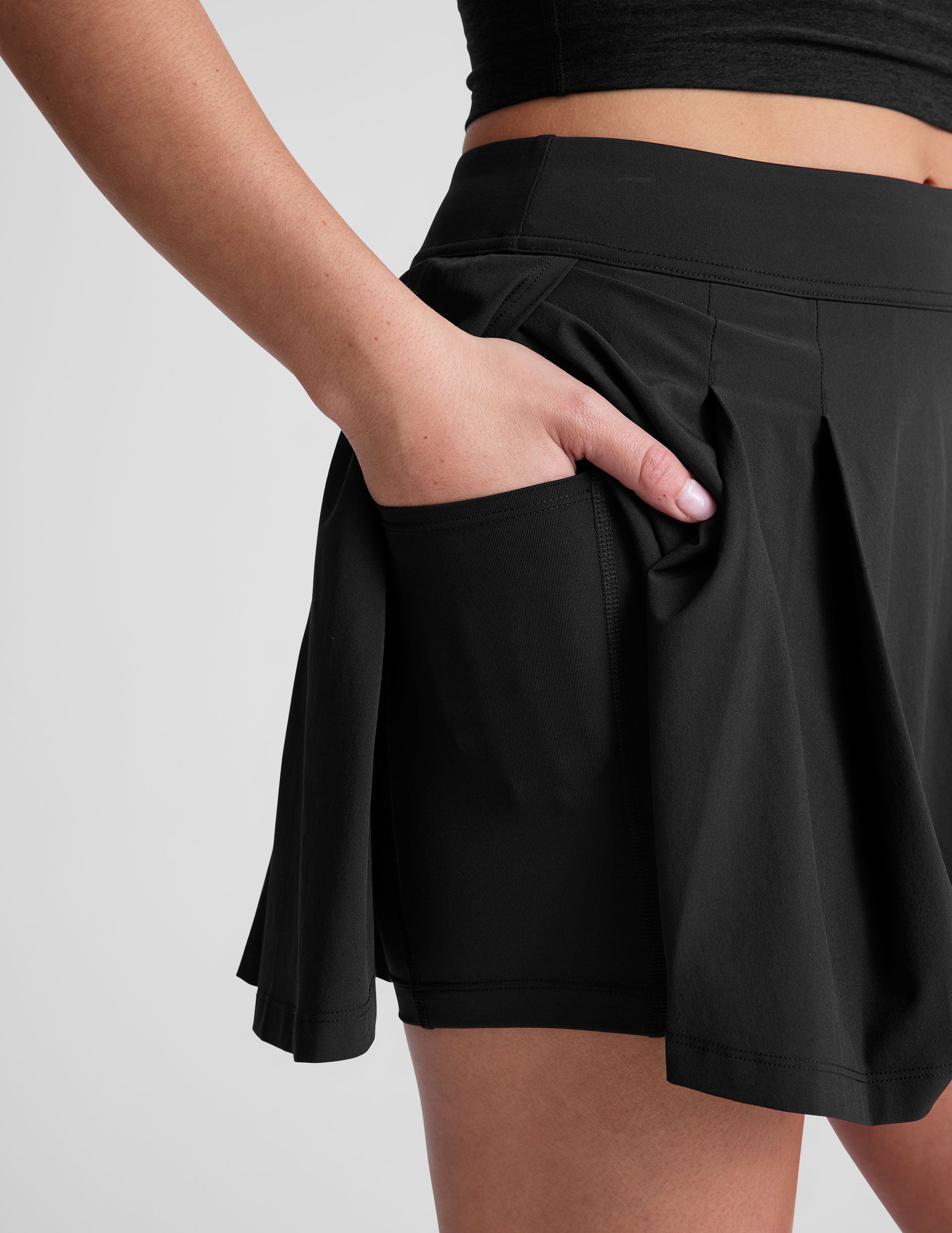 black mini pleated skirt with interior shorts with pockets.