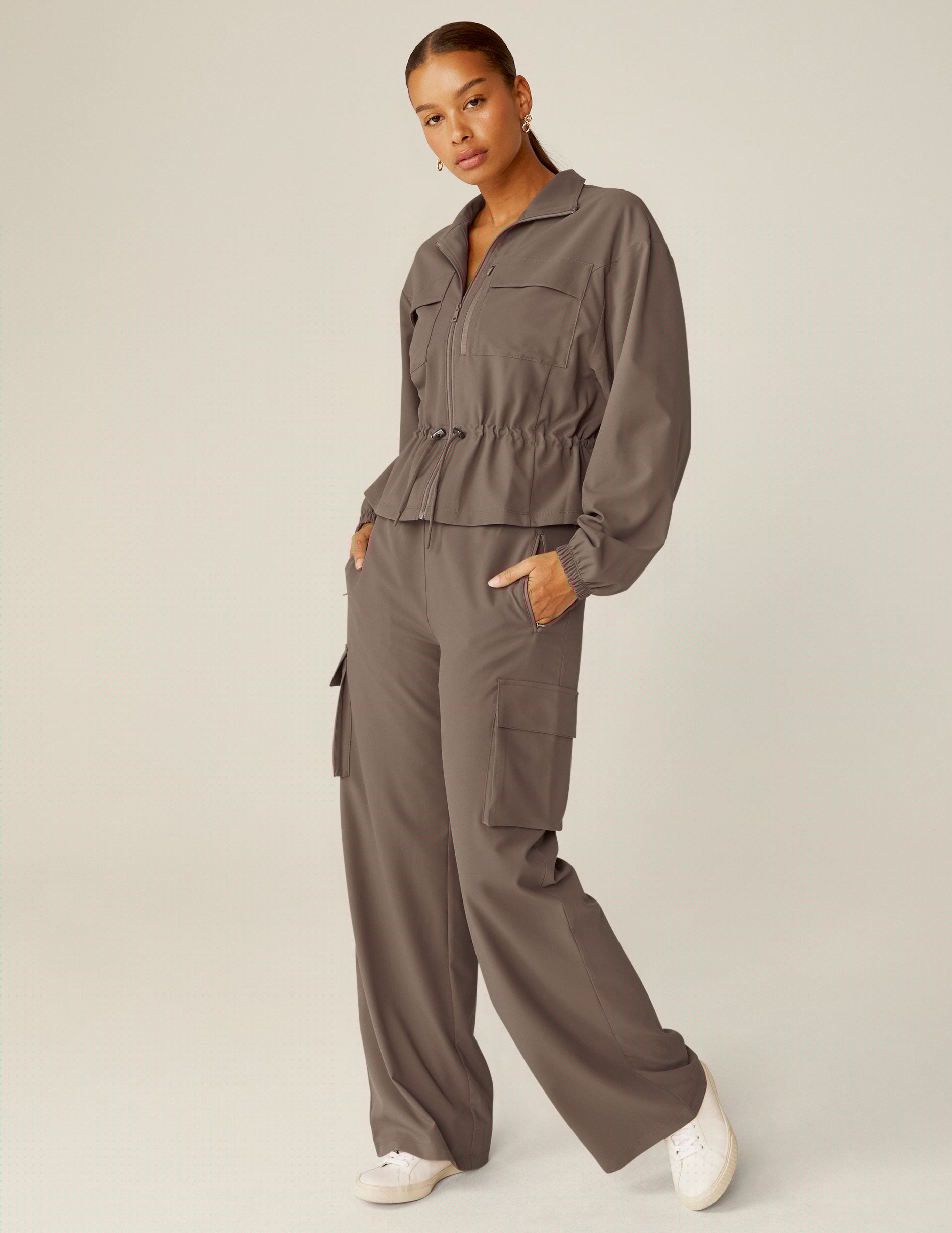 brown cargo style zip-up jacket with a drawstring tie at waist and pockets.