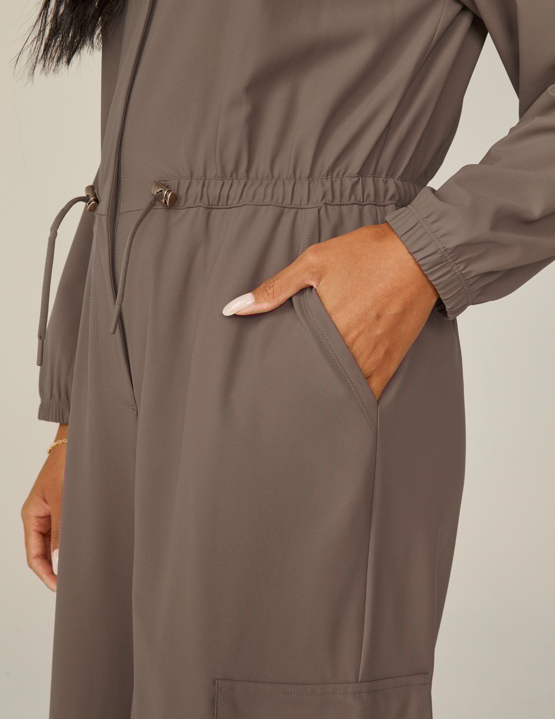 brown long sleeve cargo style jumpsuit with pockets.
