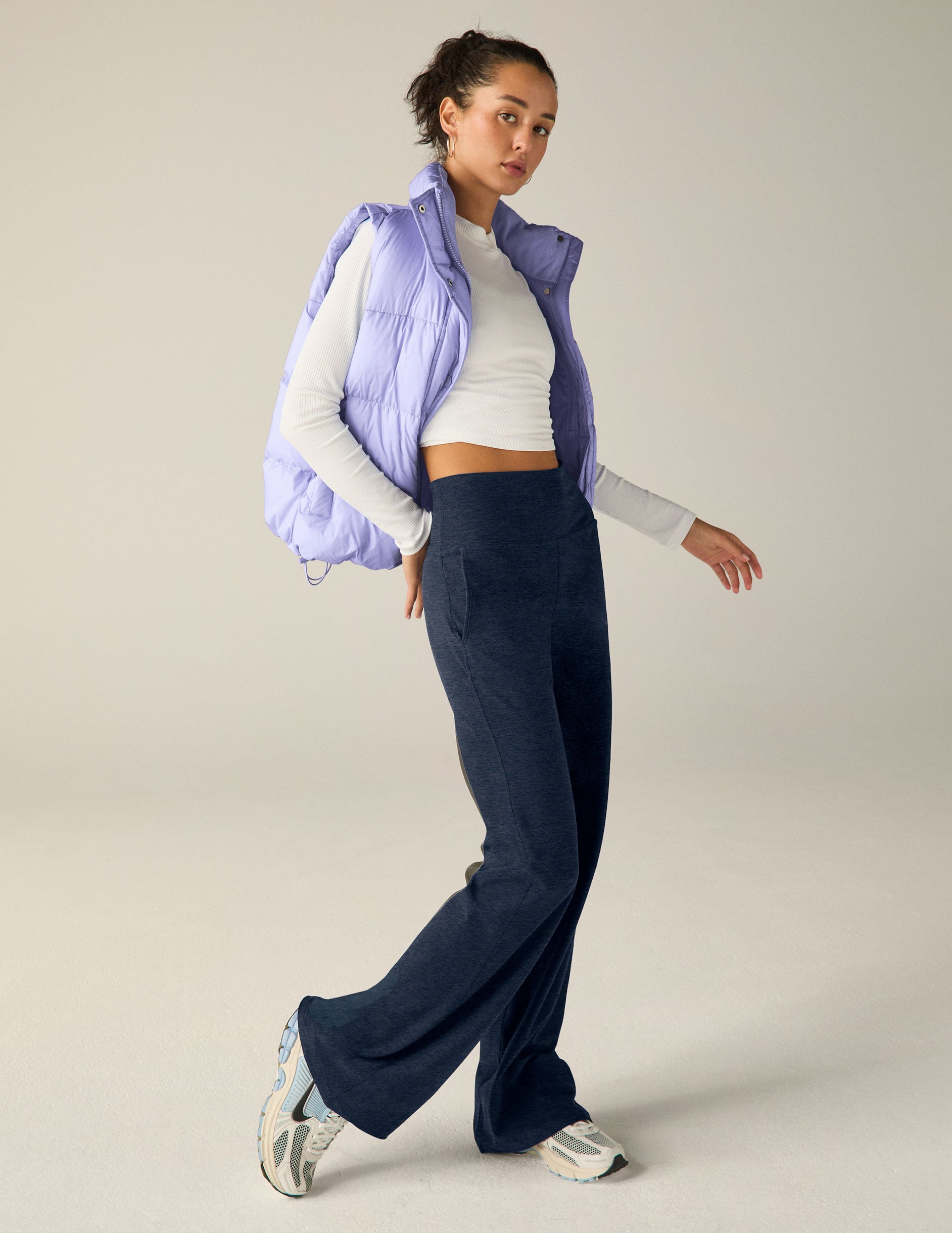 blue puffer vest with an interior bungee at hem. button and zip-up. interior and exterior pockets.