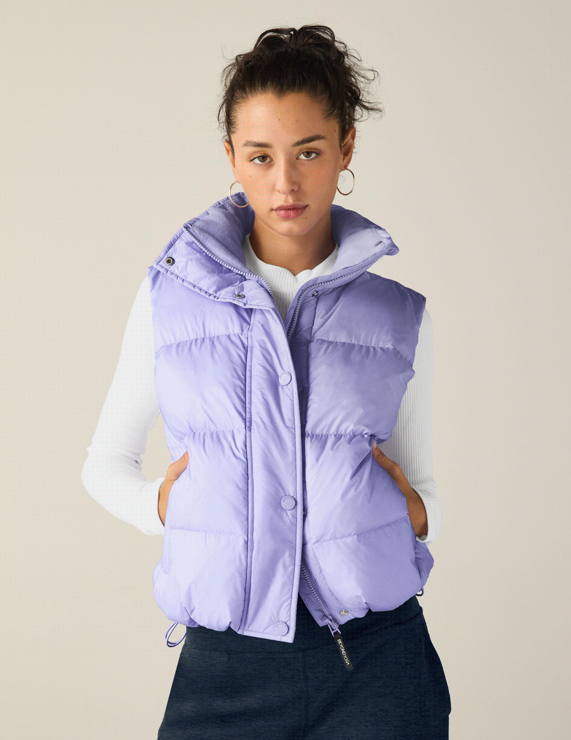 blue puffer vest with an interior bungee at hem. button and zip-up. interior and exterior pockets.