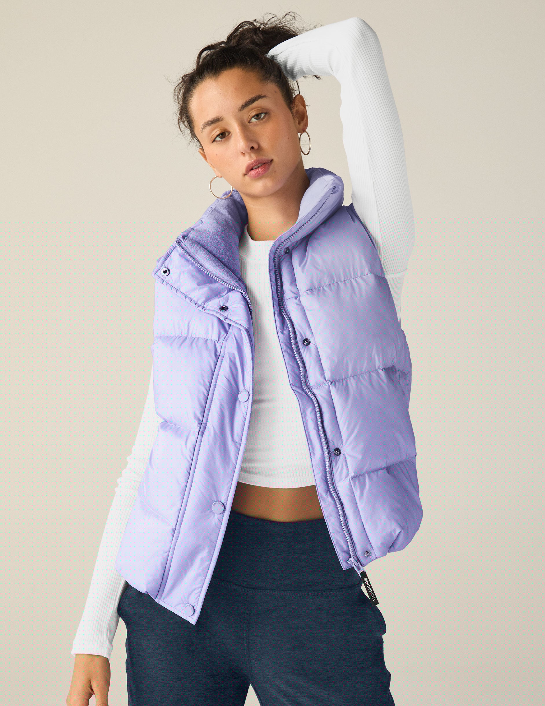blue puffer vest with an interior bungee at hem. button and zip-up. interior and exterior pockets.
