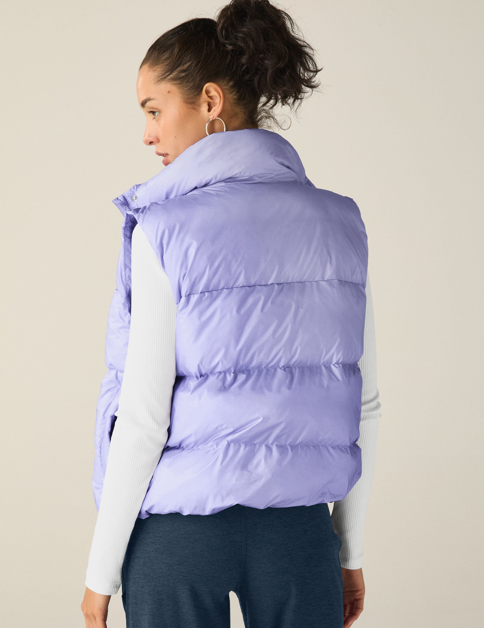 blue puffer vest with an interior bungee at hem. button and zip-up. interior and exterior pockets.