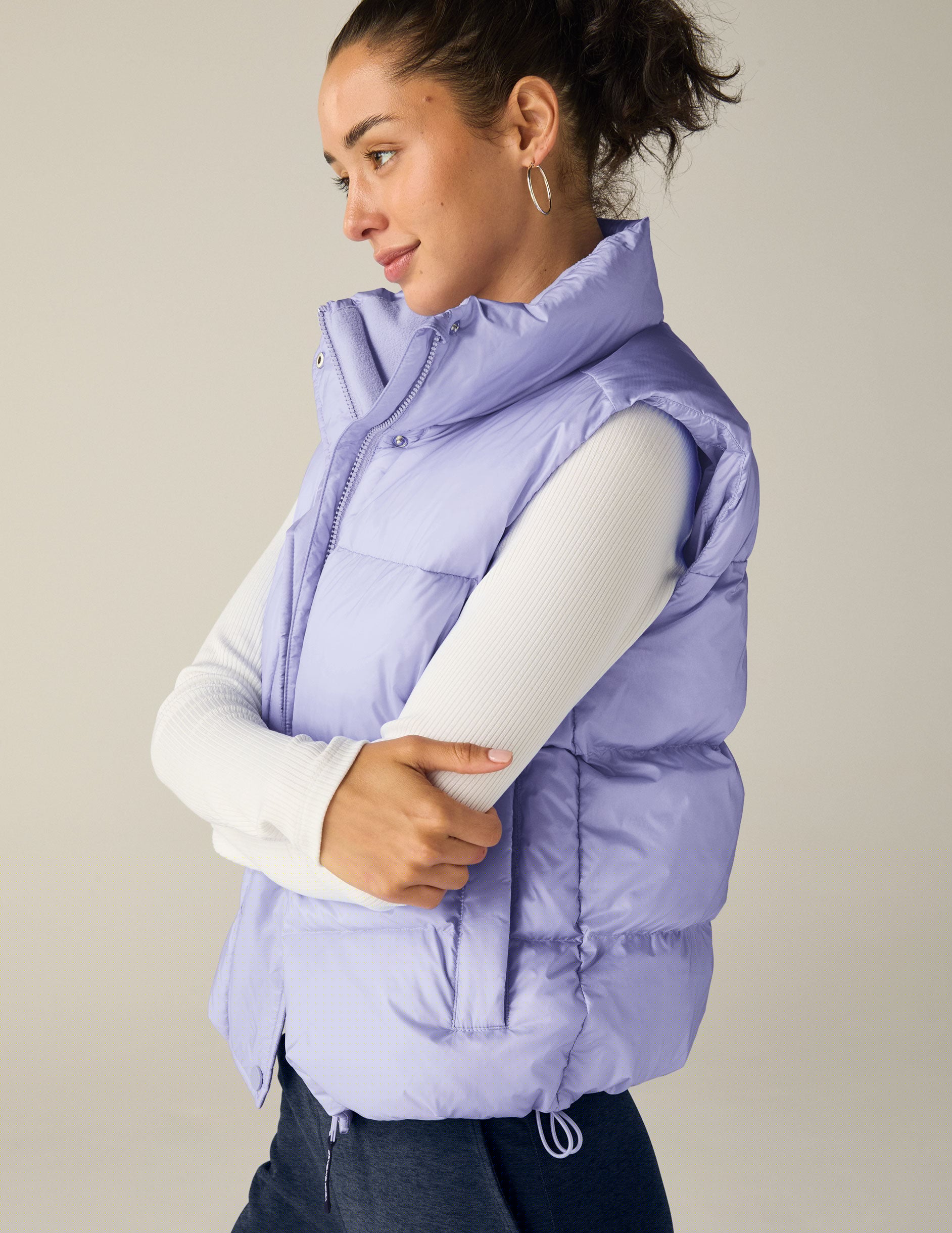 blue puffer vest with an interior bungee at hem. button and zip-up. interior and exterior pockets.