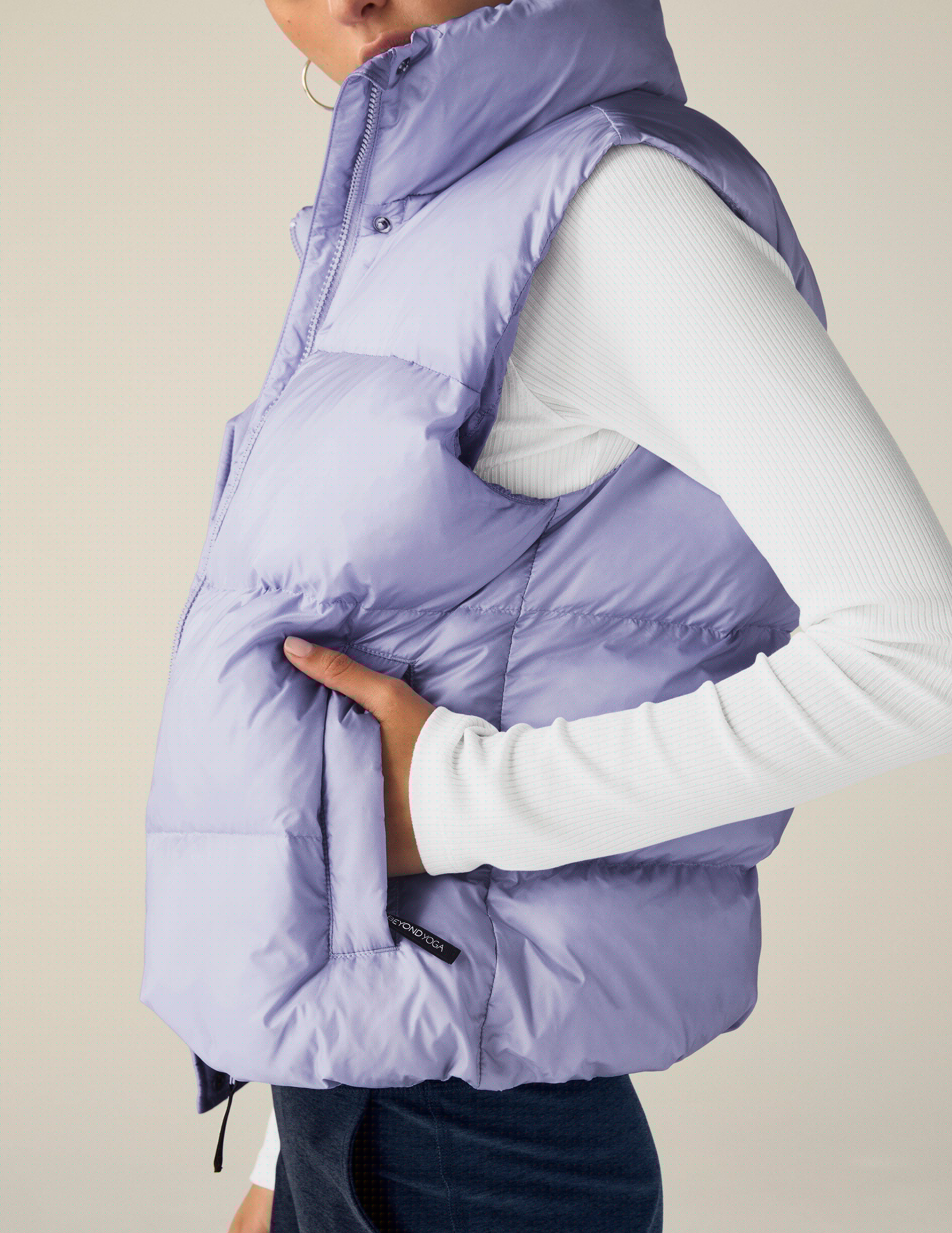 blue puffer vest with an interior bungee at hem. button and zip-up. interior and exterior pockets.