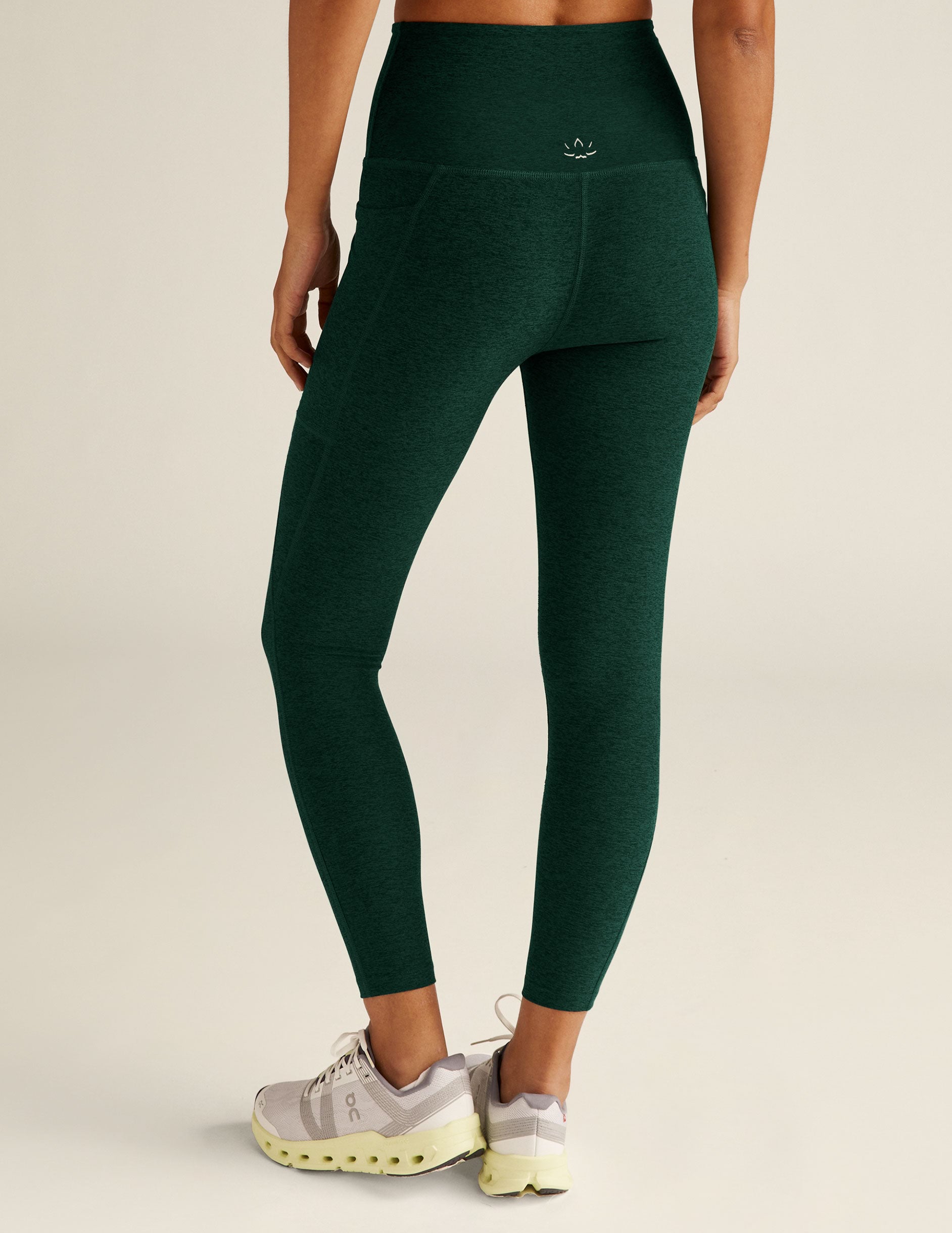 green high-waisted midi leggings with side pockets.