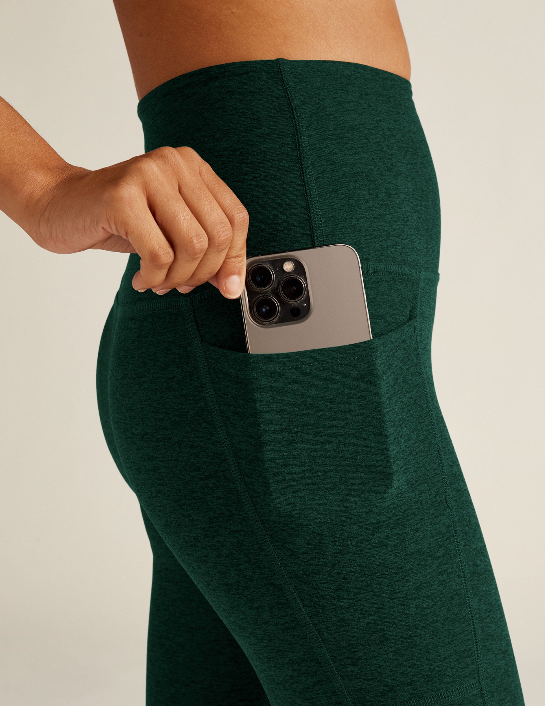 green high-waisted midi leggings with side pockets.