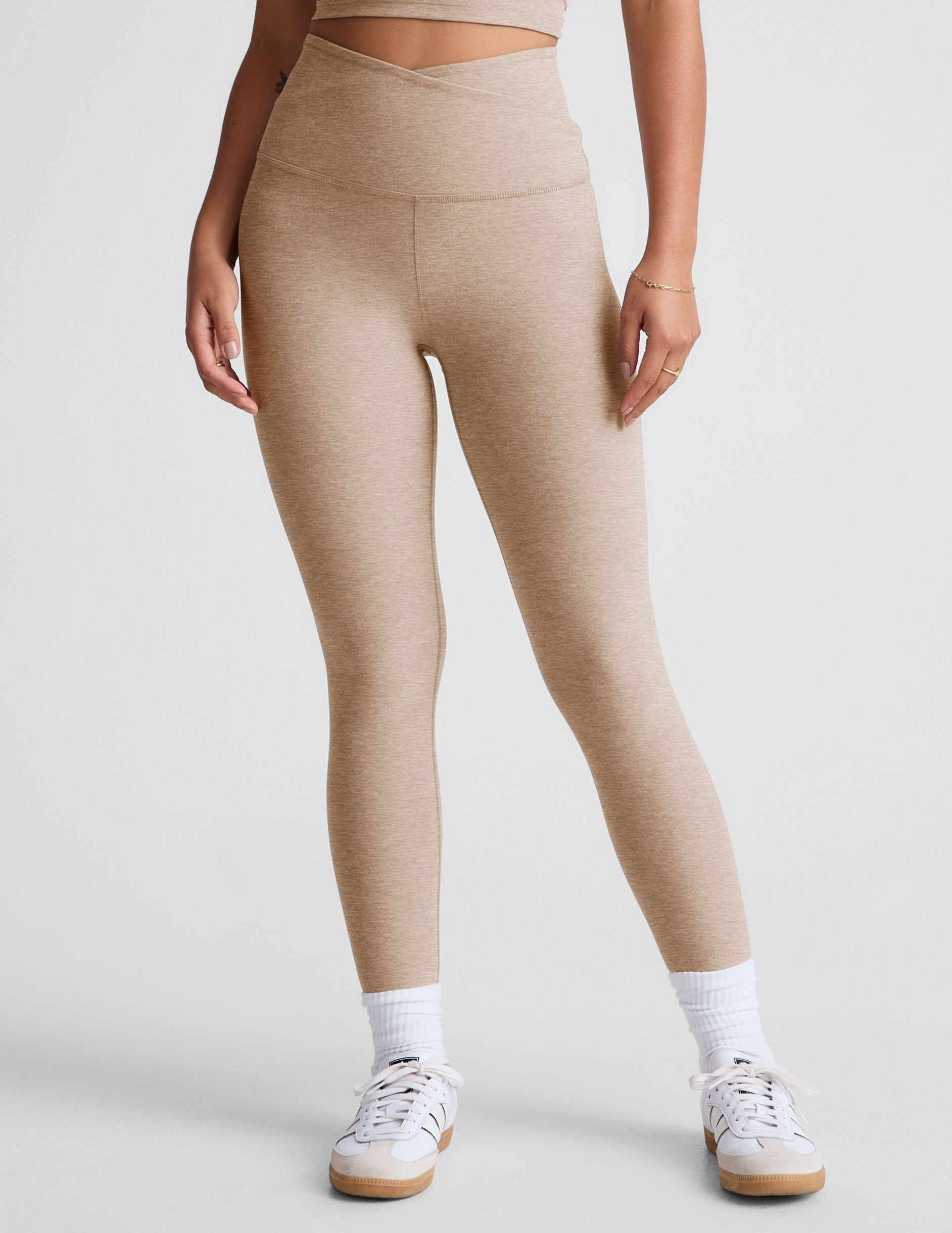 brown high-waisted midi length leggings with a crossover detail on the front waistband.