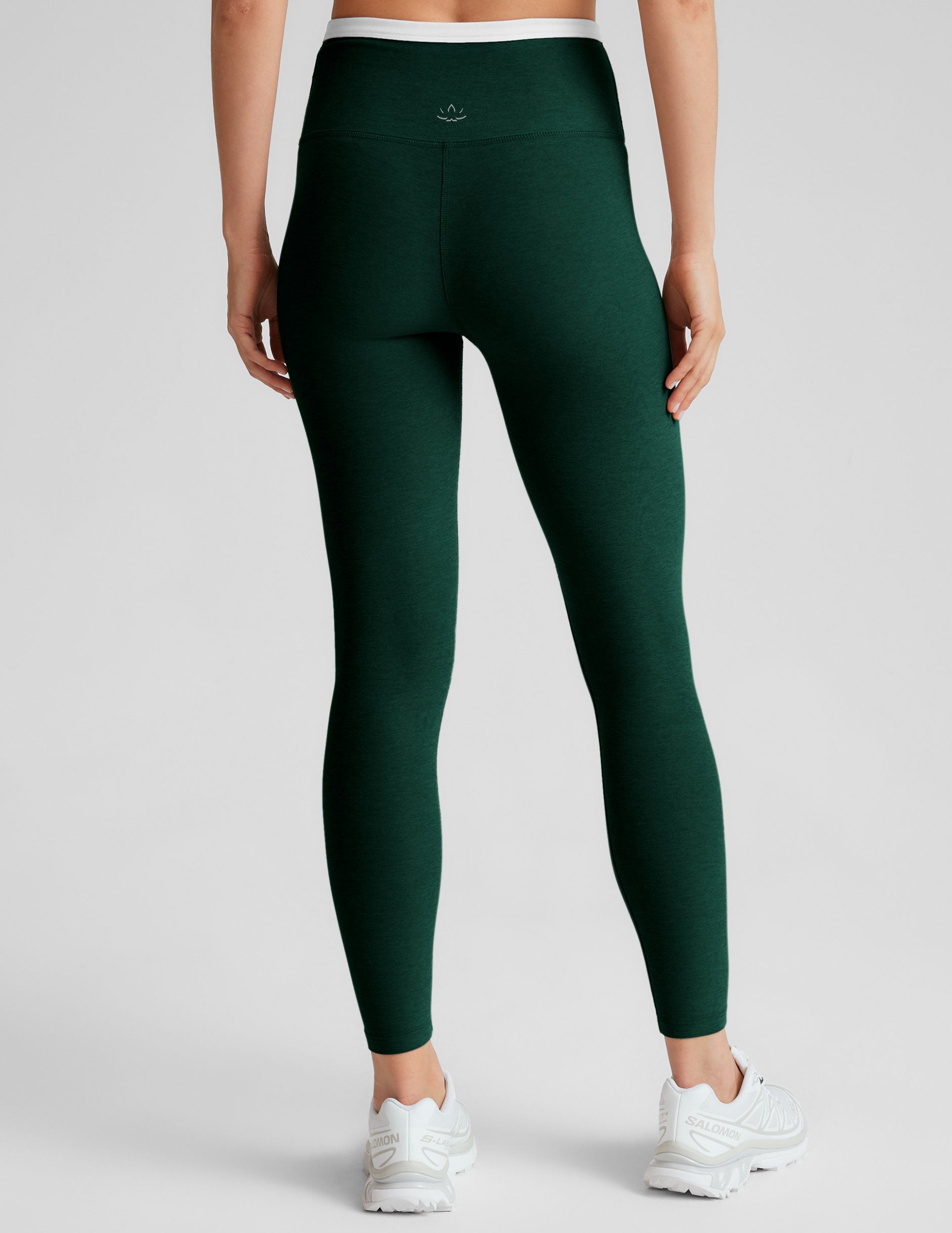 green high-waisted midi length legging with a crossover detail on the front waistband with white contrast binding along waistline.