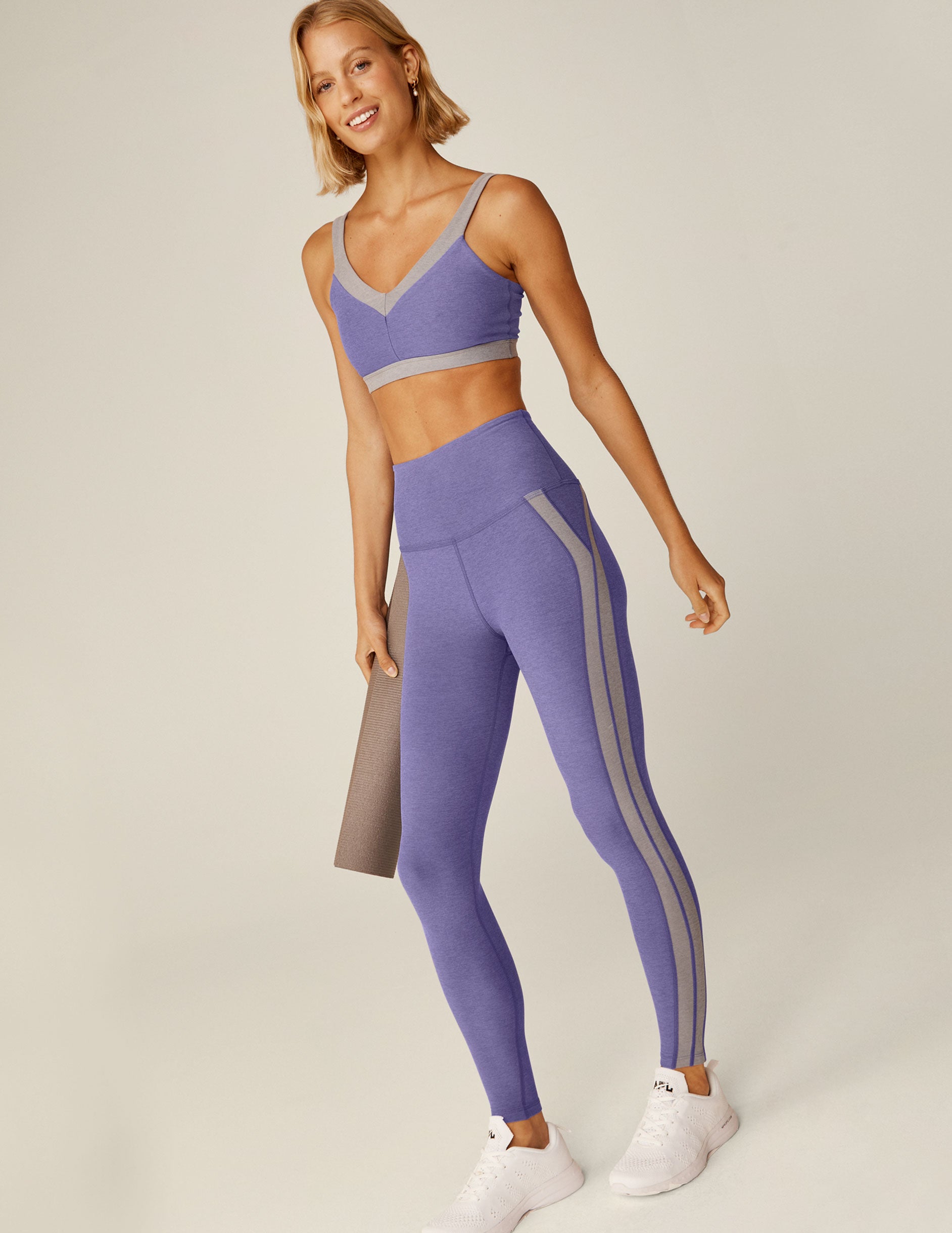 purple high-waisted midi leggings with gray trim down the side.
