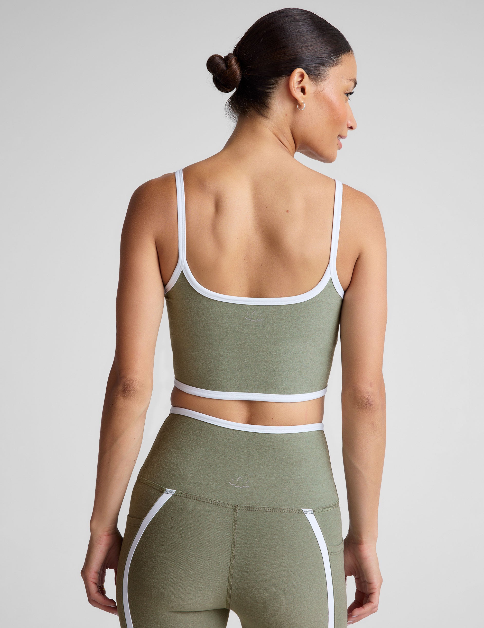 green cropped tank top with contoured princess seams and white piping detail along edges.