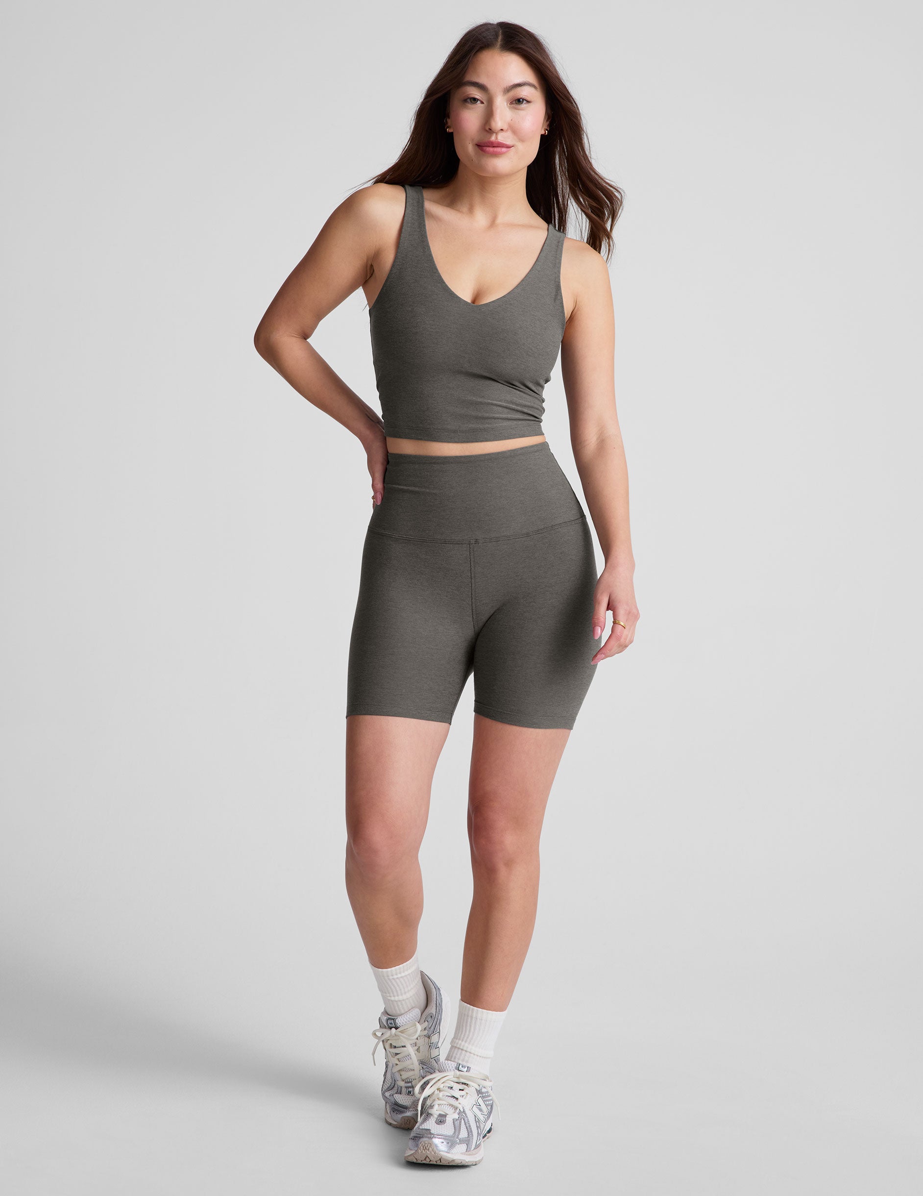 gray cropped length tank top with a front and back V neckline and self shelf bra. paired with high-waisted 5" inseam length biker shorts.