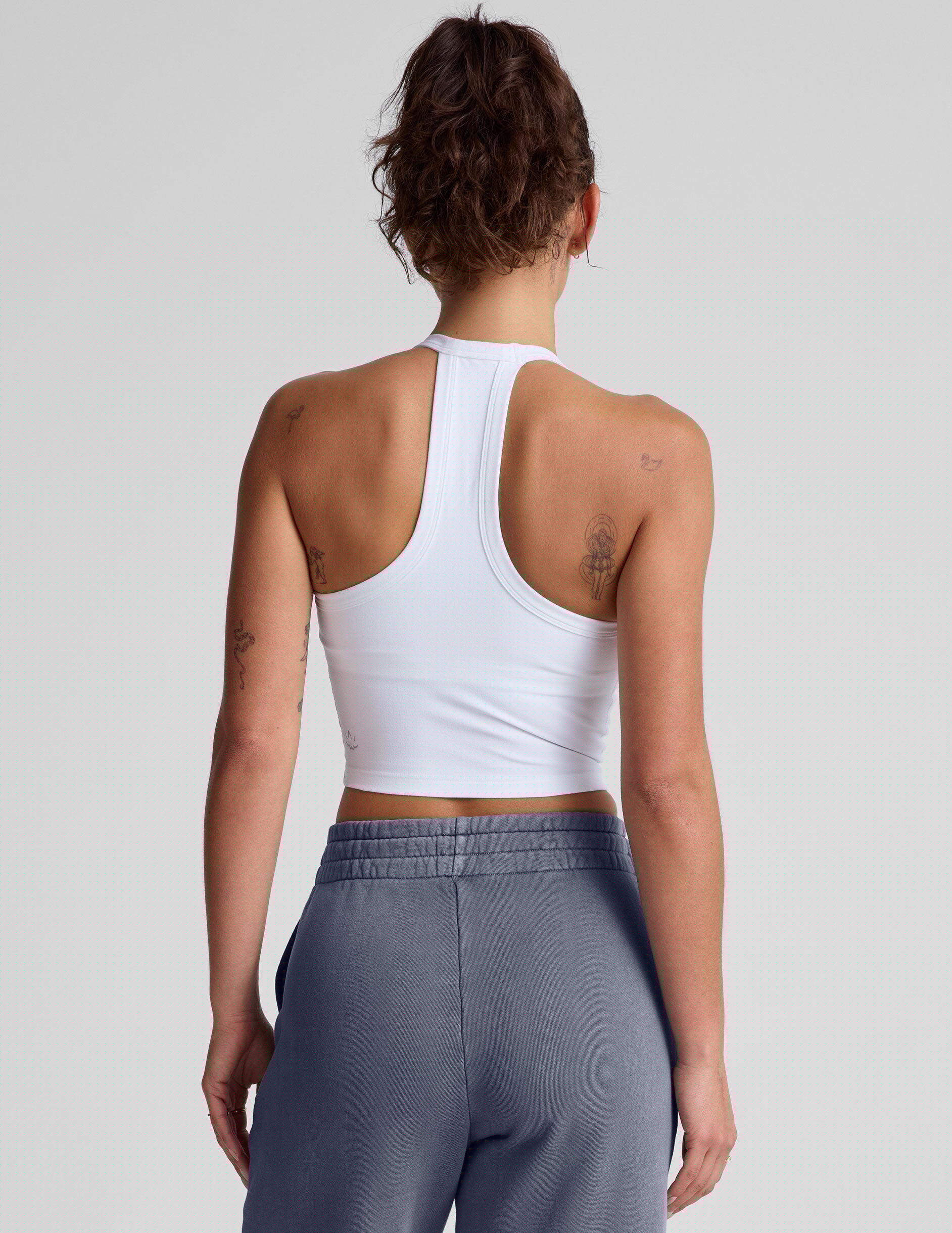 white cropped tank top with a v neckline and high racerback.