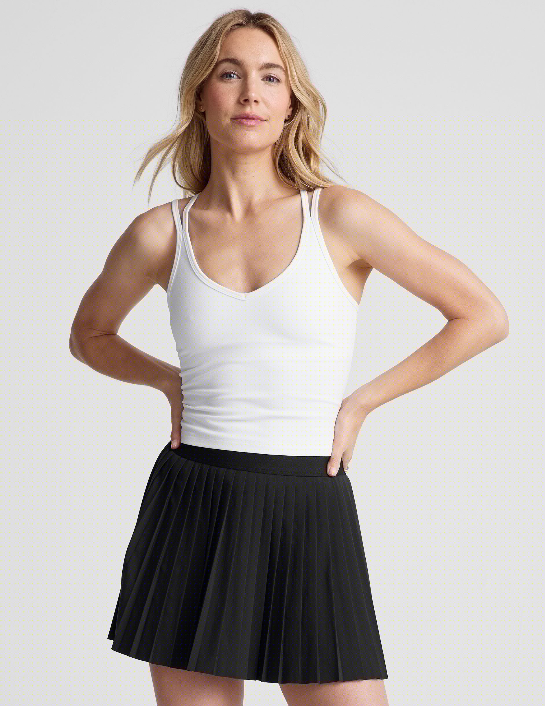 white waist length, V neckline tank top with a self shelf bra and criss-cross strap back detail.