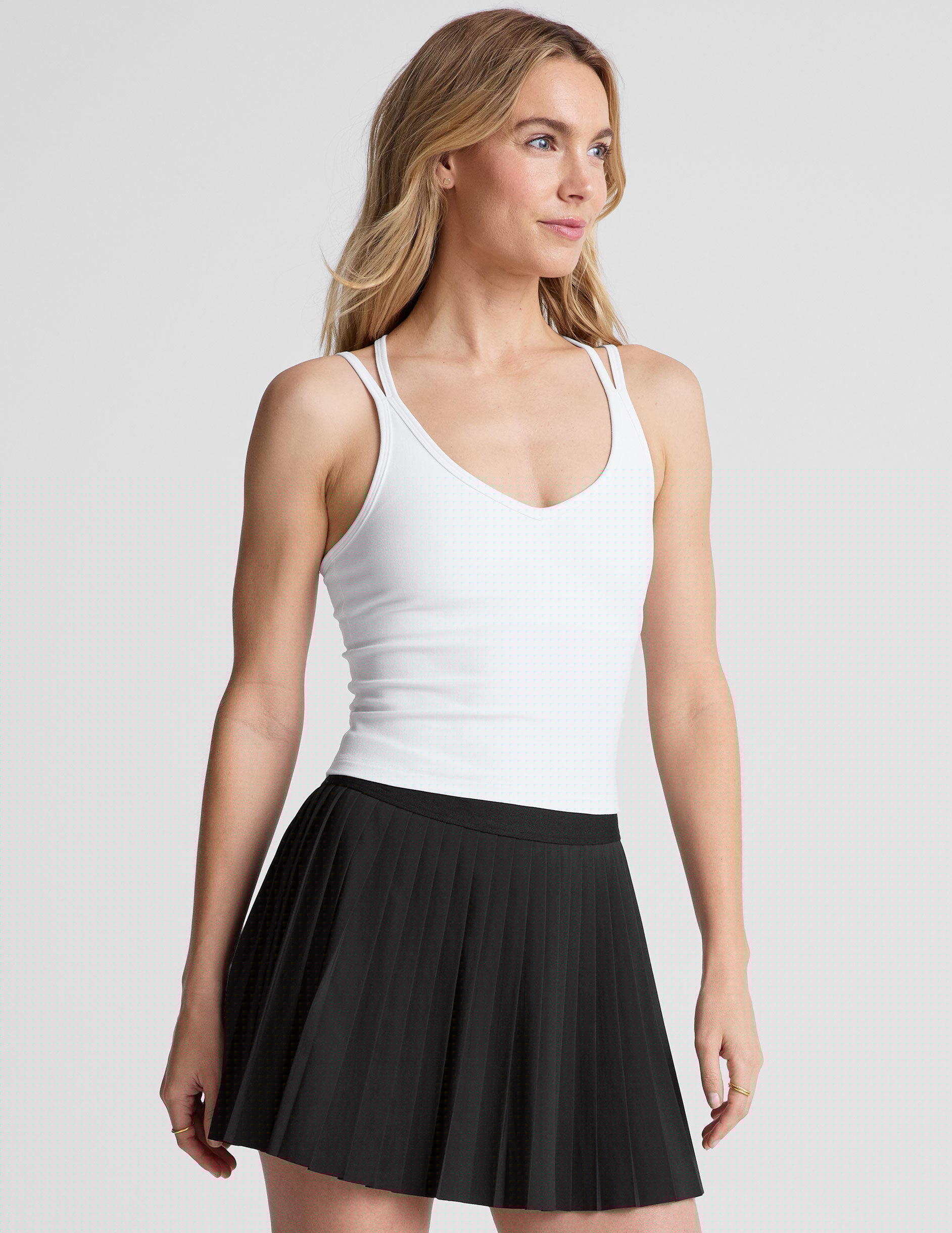 white waist length, V neckline tank top with a self shelf bra and criss-cross strap back detail.