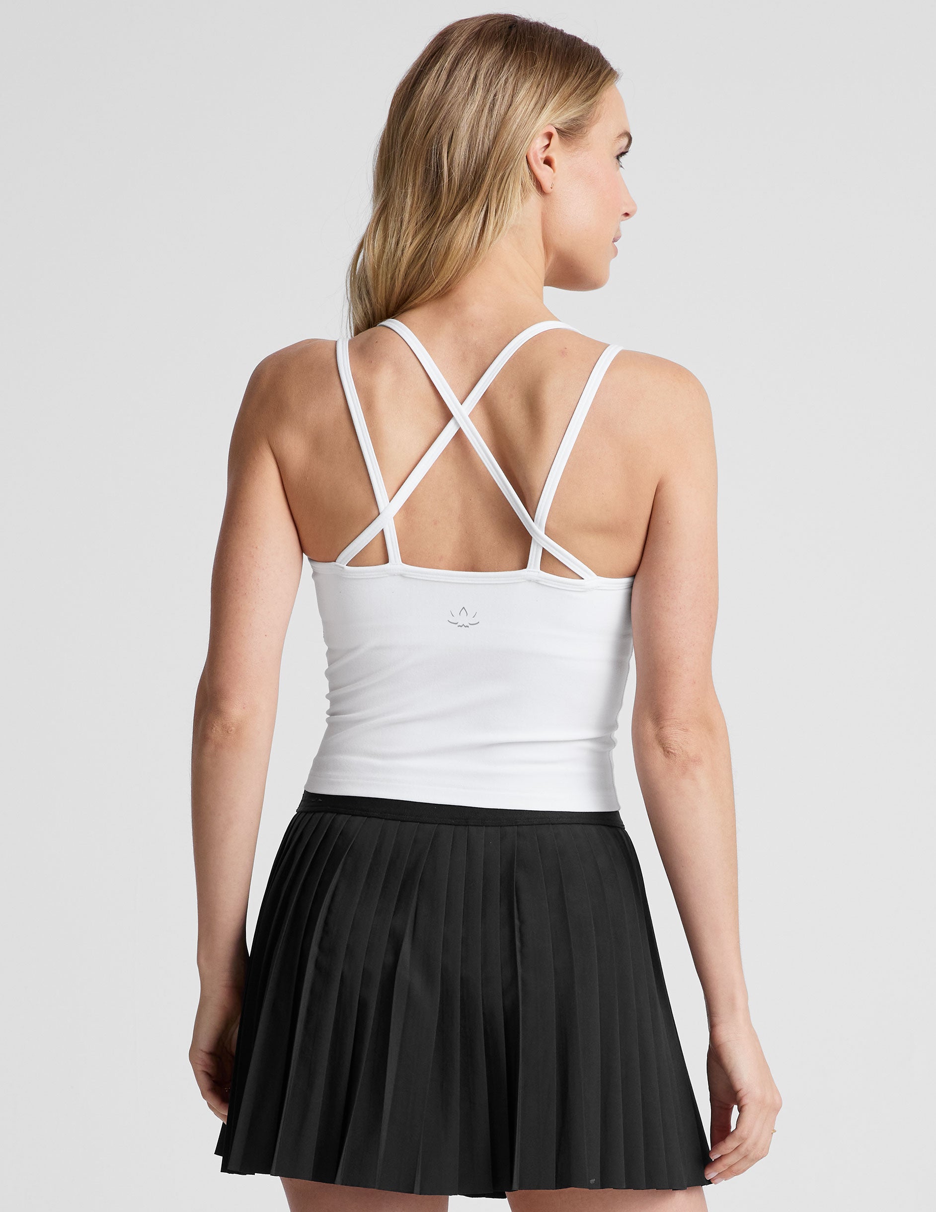 white waist length, V neckline tank top with a self shelf bra and criss-cross strap back detail.