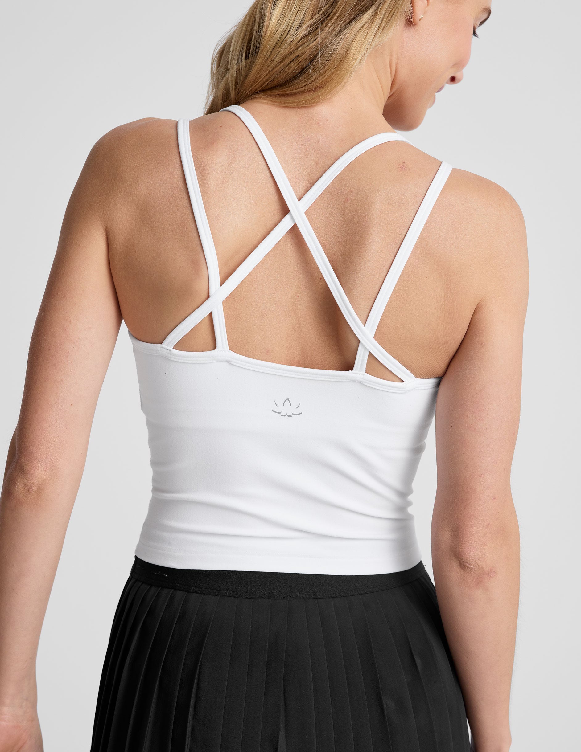 white waist length, V neckline tank top with a self shelf bra and criss-cross strap back detail.