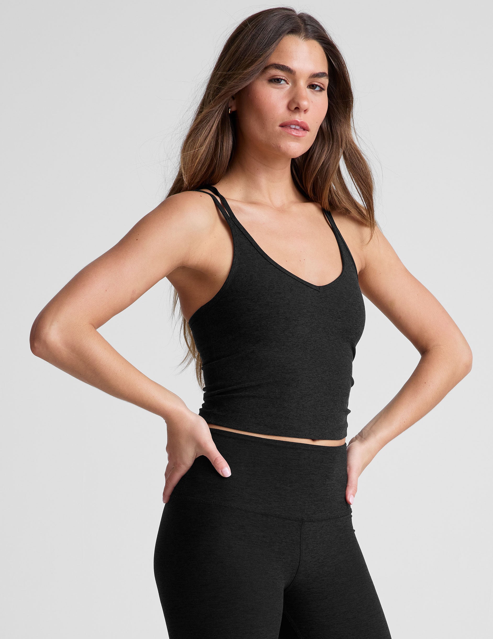 white waist length, V neckline tank top with a self shelf bra and criss-cross strap back detail.