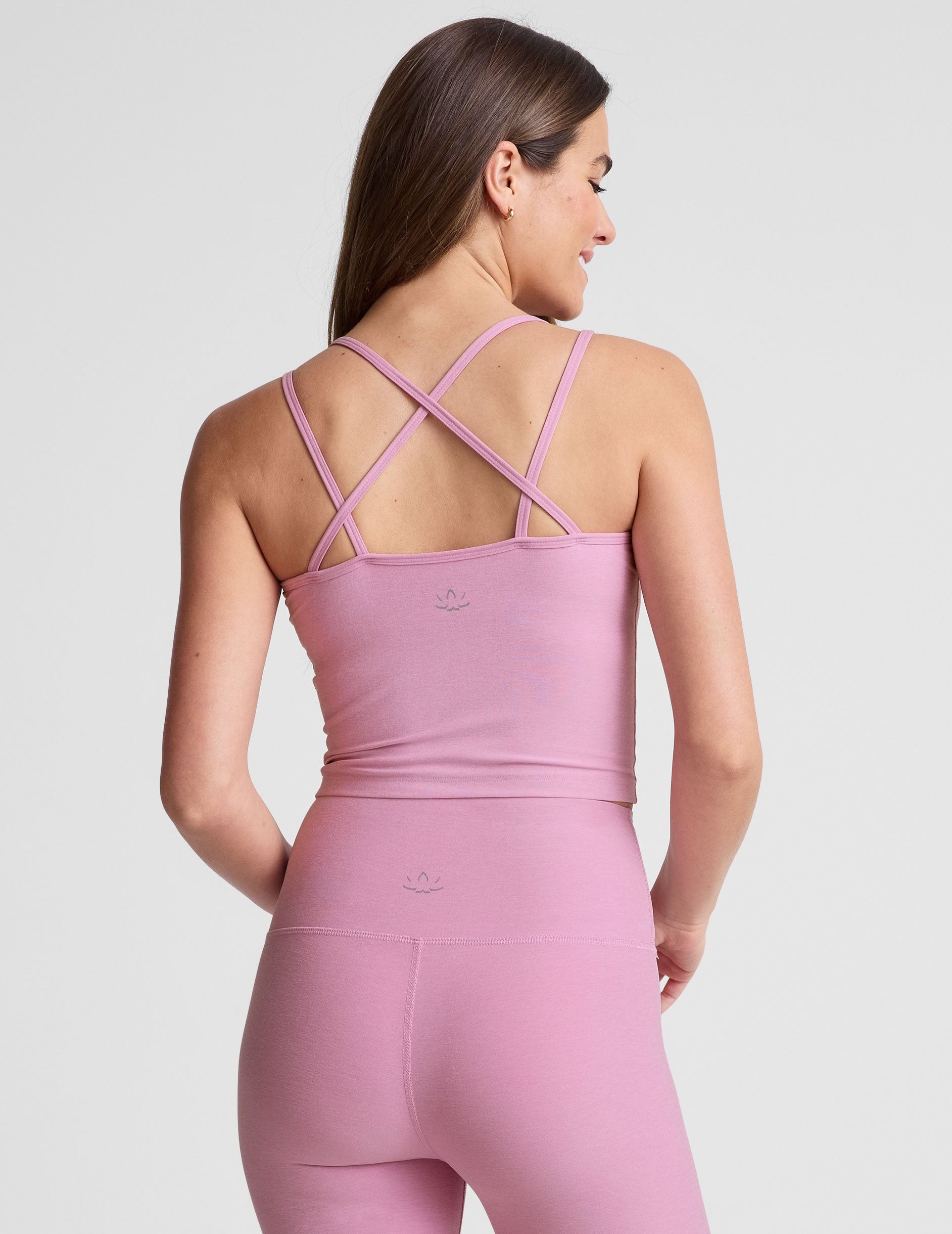 pink waist length, V neckline tank top with a self shelf bra and criss-cross strap back detail.