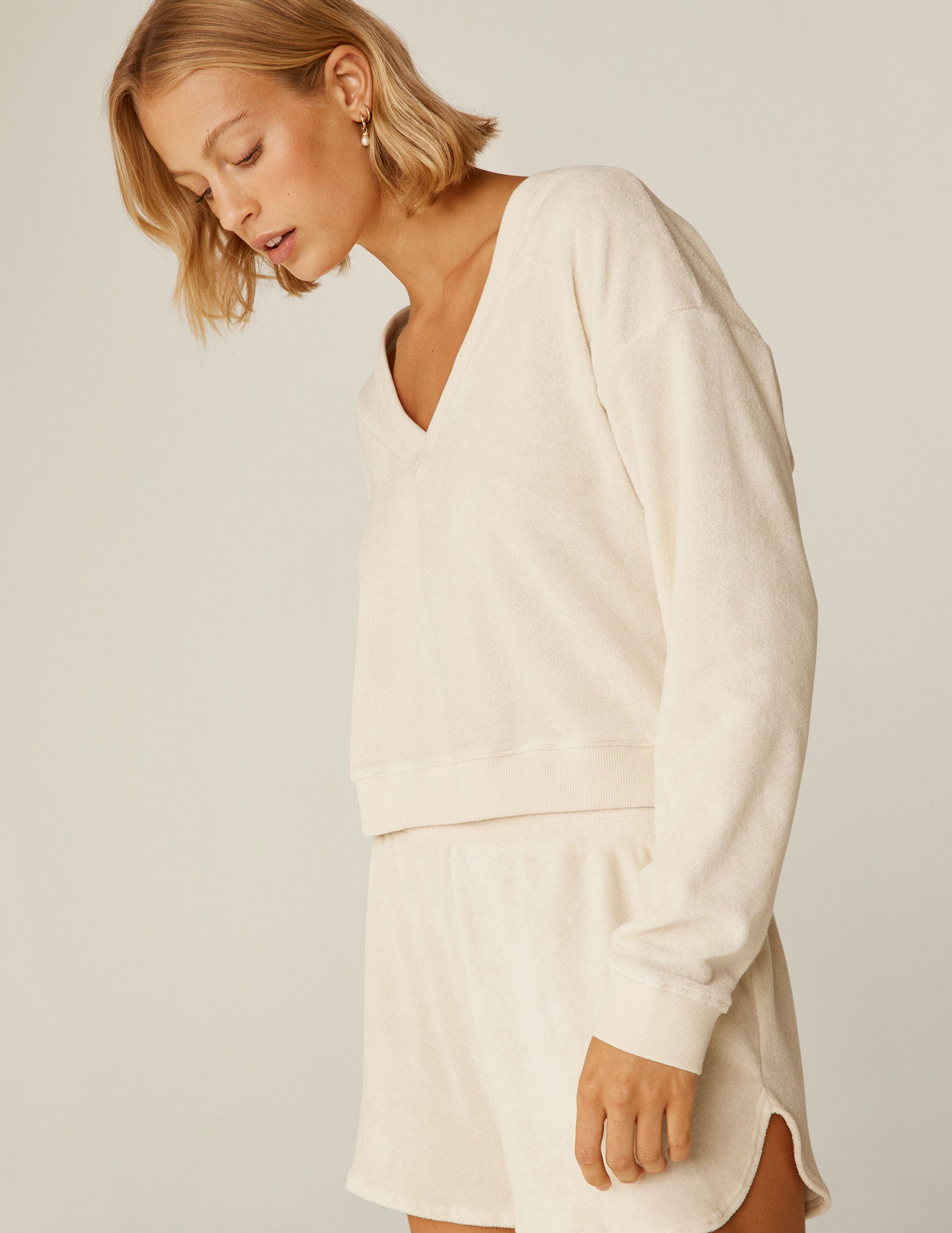 cream colored terry v-neck long sleeve pullover.