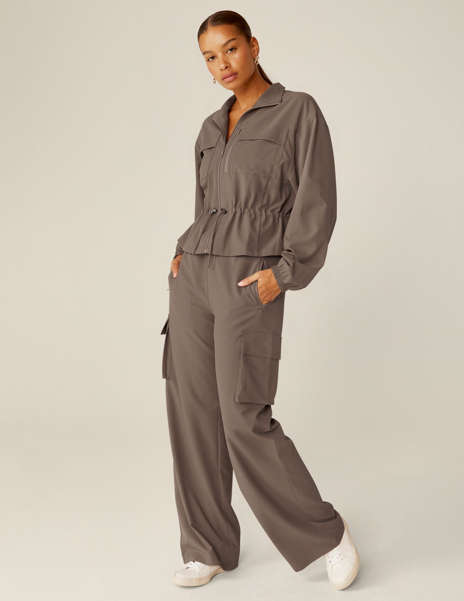 brown cargo style zip-up jacket with a drawstring tie at waist and pockets. 
