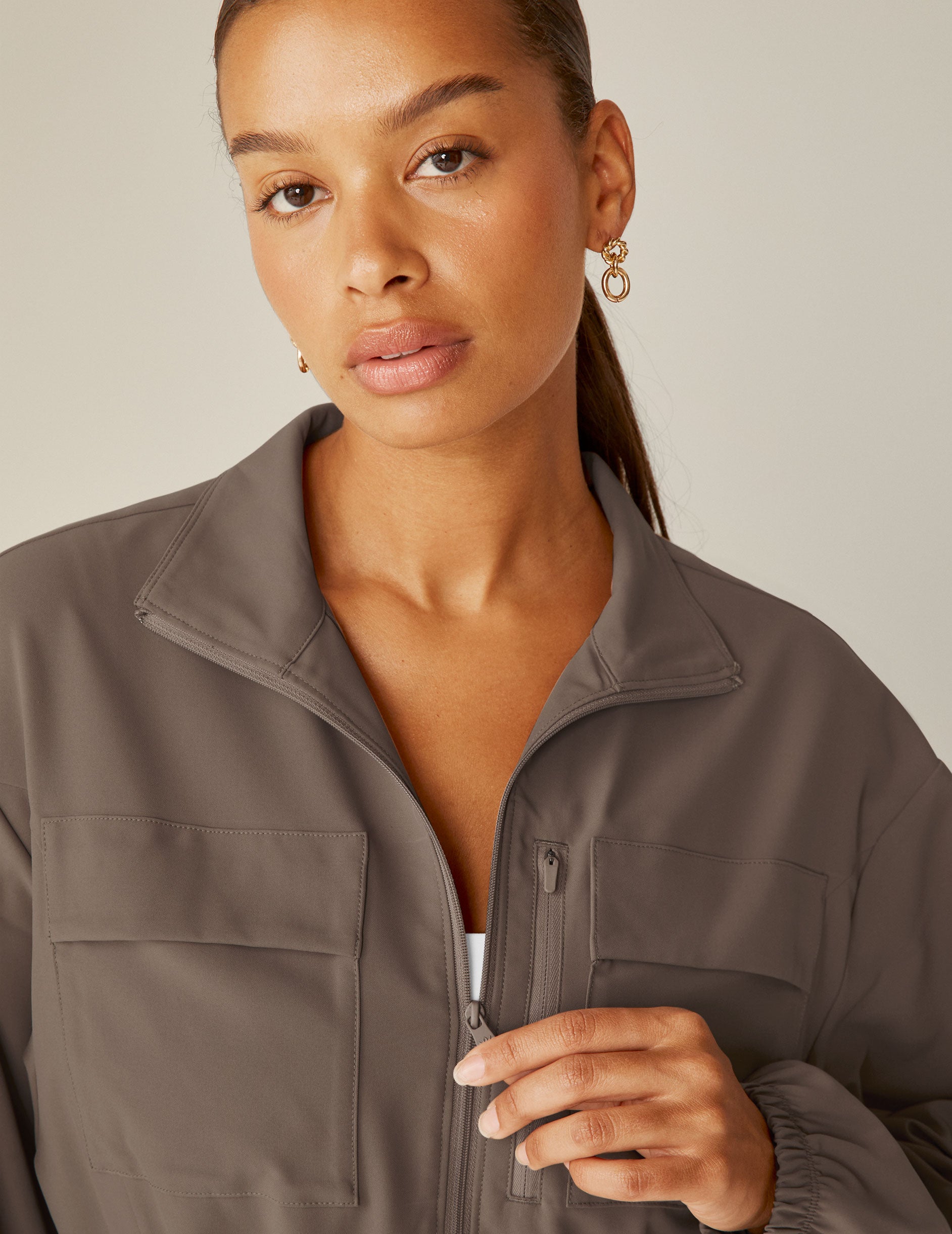 brown cargo style zip-up jacket with a drawstring tie at waist and pockets. 